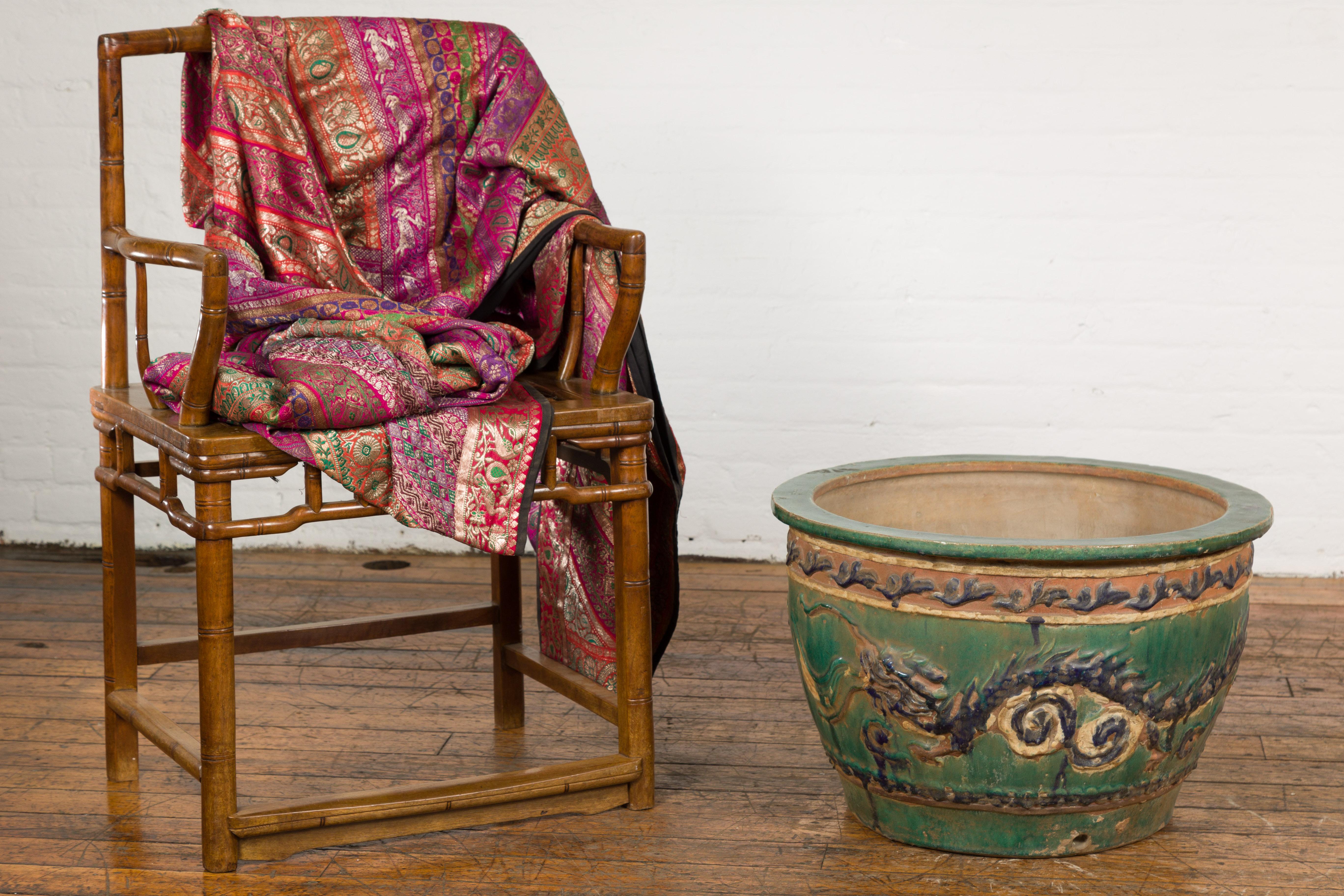 Jardinière annamite du XIXe siècle, de couleur verte, bleue et ocre, provenant du Vietnam, avec des motifs de dragon et de frise de feuillage, une patine d'usage et un petit trou d'évacuation à l'avant. Cette ancienne jardinière annamite du XIXe