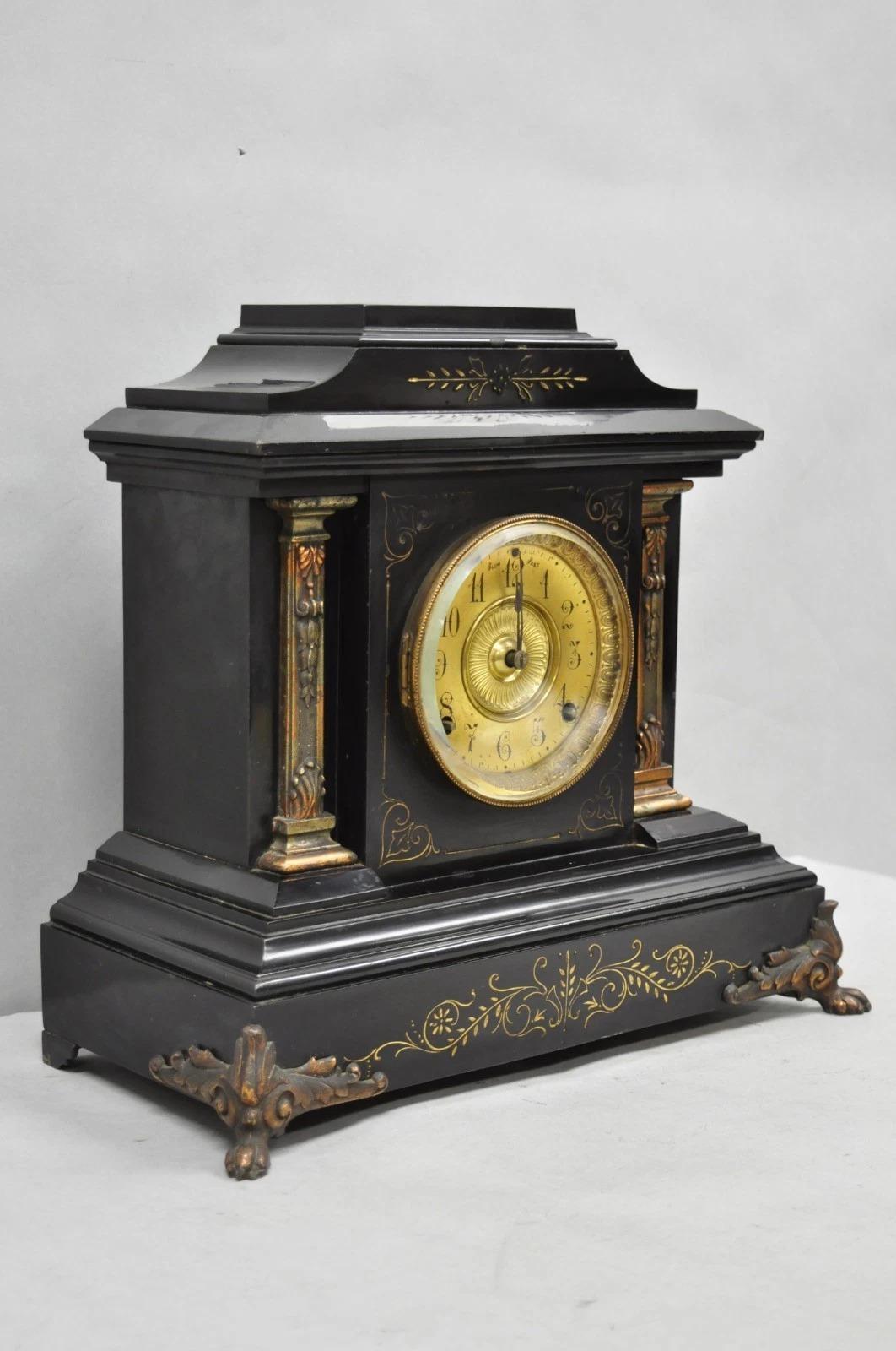 Antique Ansonia Empire Black Enameled Metal Mantel Clock with Bronze Coated Cast Iron Columns, Beveled Glass Door, Scrolling Detail, and Claw Feet. Circa Late 19th Century. Measurements: 15