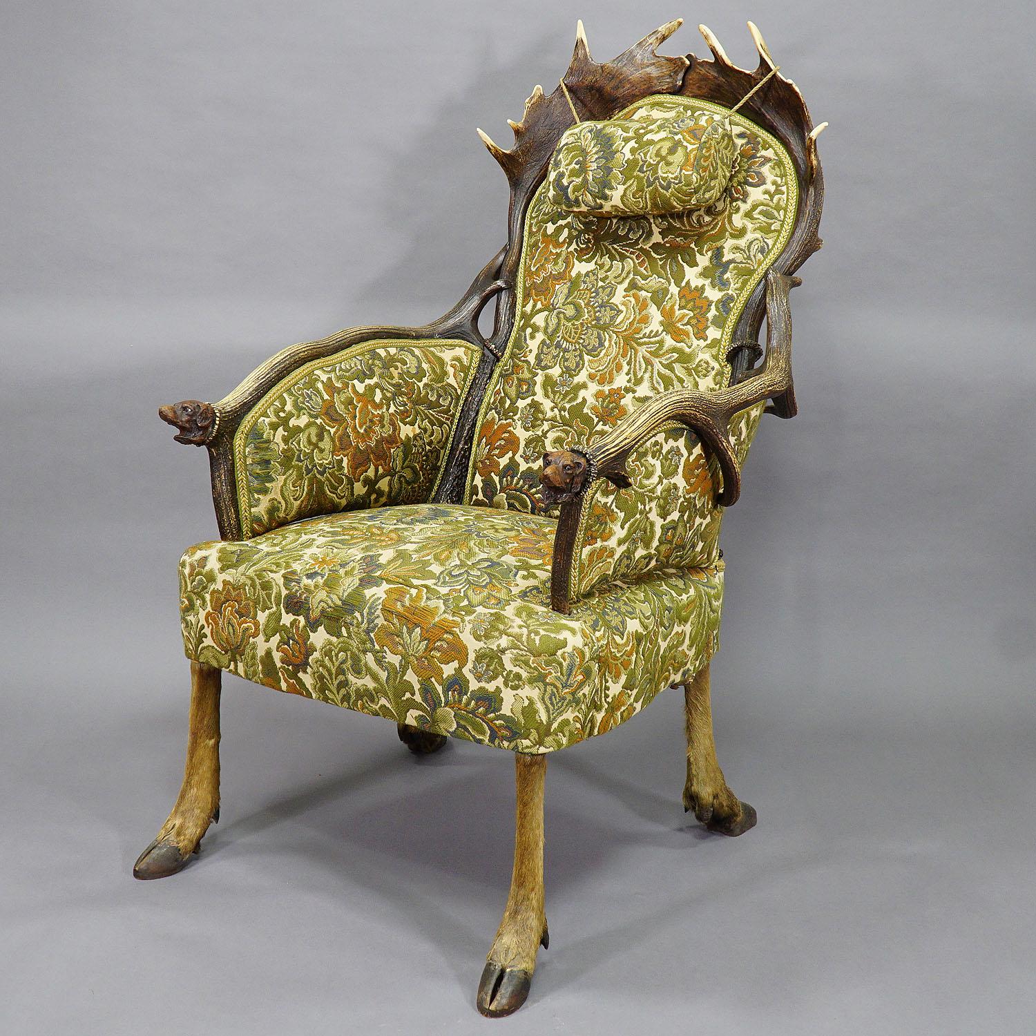 A rare antler armchair made of original horns from the stag and fallow deer. Feet made of original deer legs reinforced with wood. The unusual chair is elaborately manufactured with fine carved horn roses and canvas upholstery. Attributed to H.F.C.