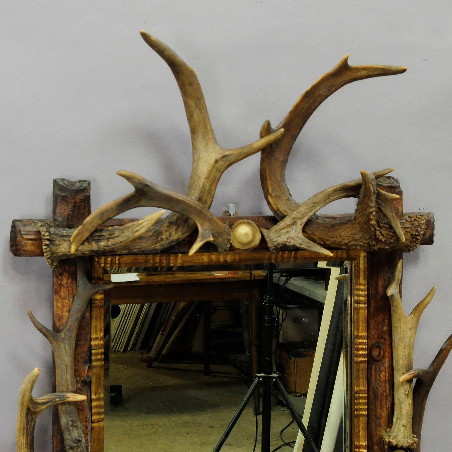 An impressive antler mirror decorated with turned horn roses and antler pieces of the deer and Virginia deer, Germany, Black Forest, circa 1910.

Measures: width 18.9