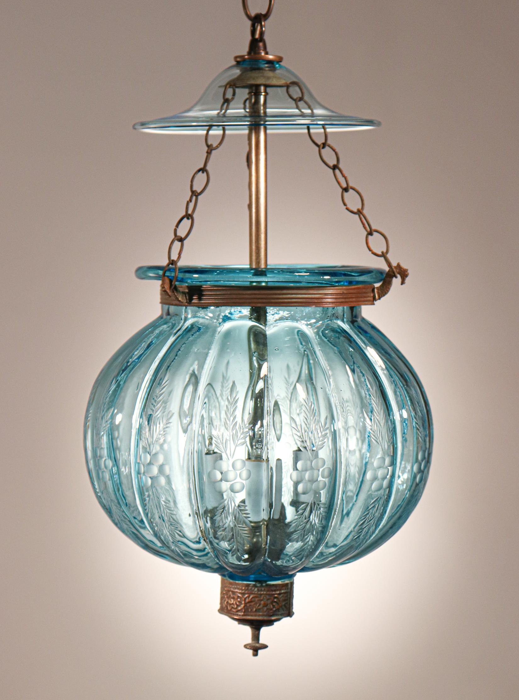 A rare antique Belgian melon bell jar lantern features excellent quality aqua-blue hand blown glass and a finely etched wheat motif. The lantern's brass finial/candle holder base, which is slightly canted is original to the lantern. The rolled brass