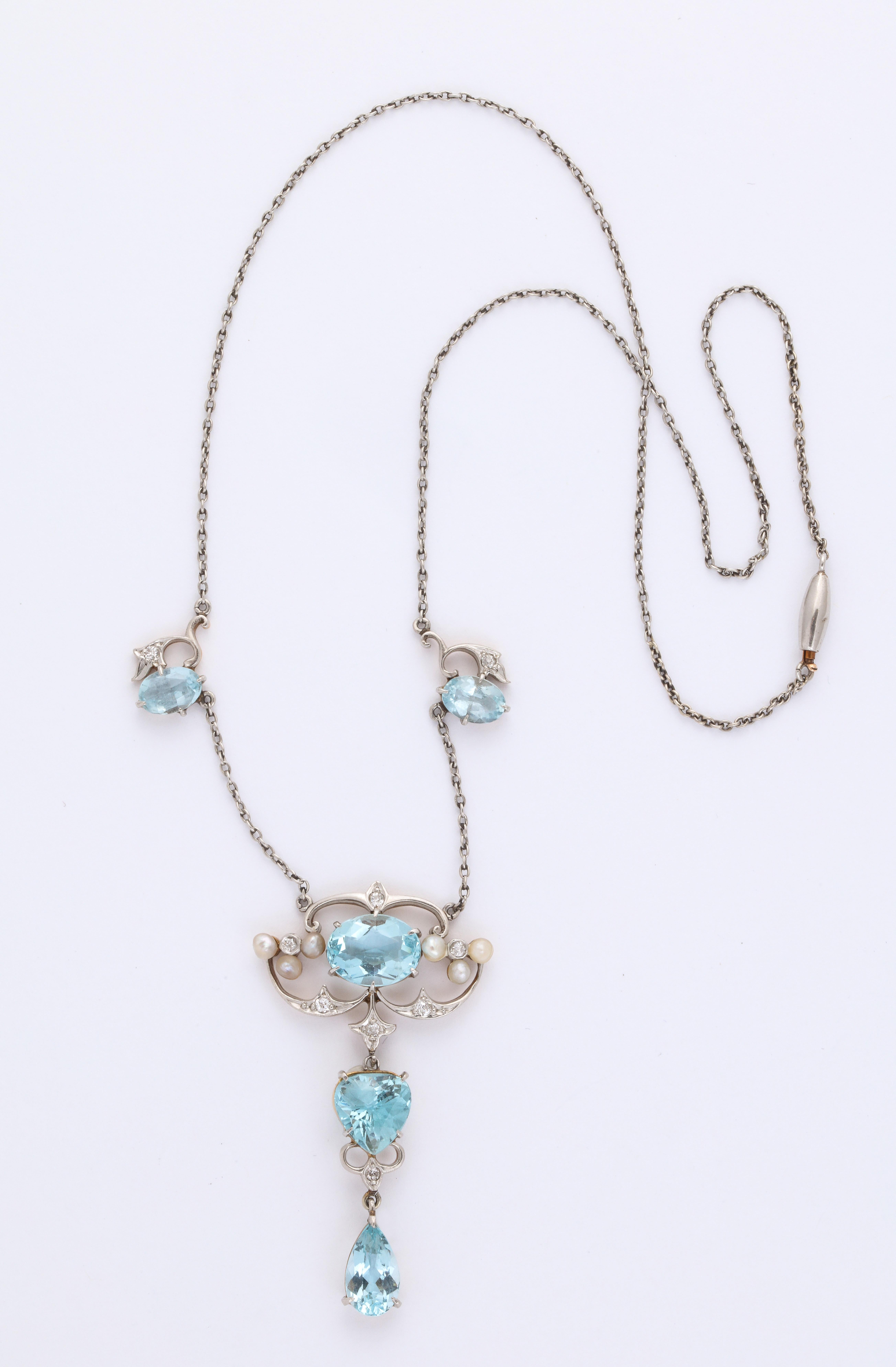 A beautiful Antique Aquamarine and Diamond necklace with a center pendant comprised of three different cuts of Aquamarines oval pear teardrop and old mine cut diamonds.  A delicate design set in platinum  with two smaller Aquamarines, spaced on