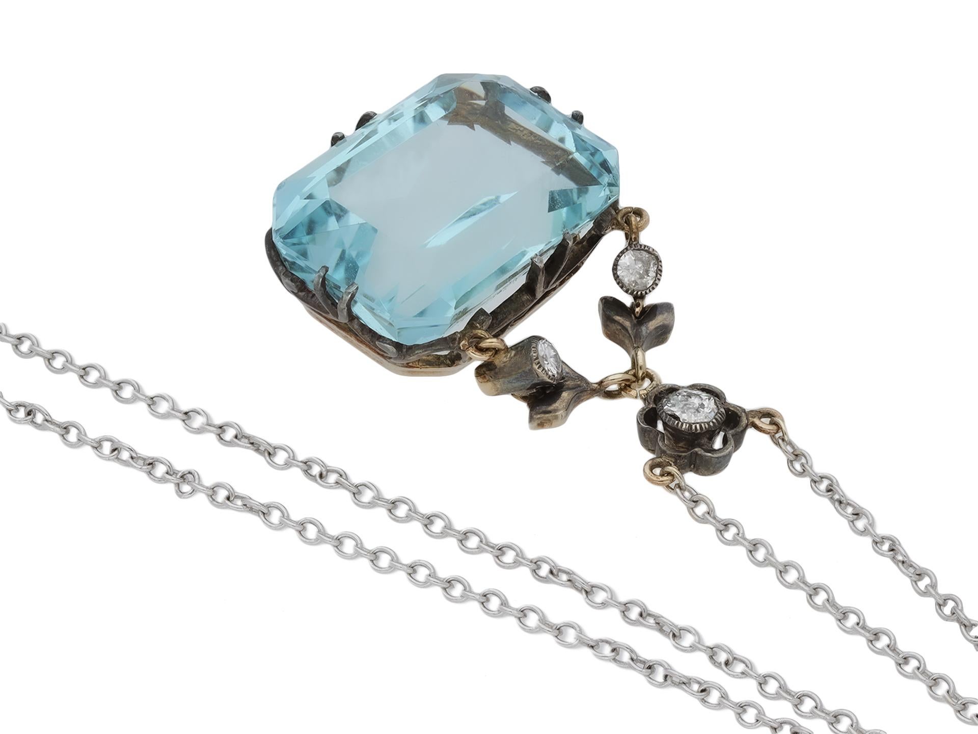 Aquamarine and diamond pendant. Set with one octagonal scissor cut natural unenhanced aquamarine in an open back split claw setting with an approximate weight of 17.00 carats, set to top with three round old cut diamonds in open back rubover