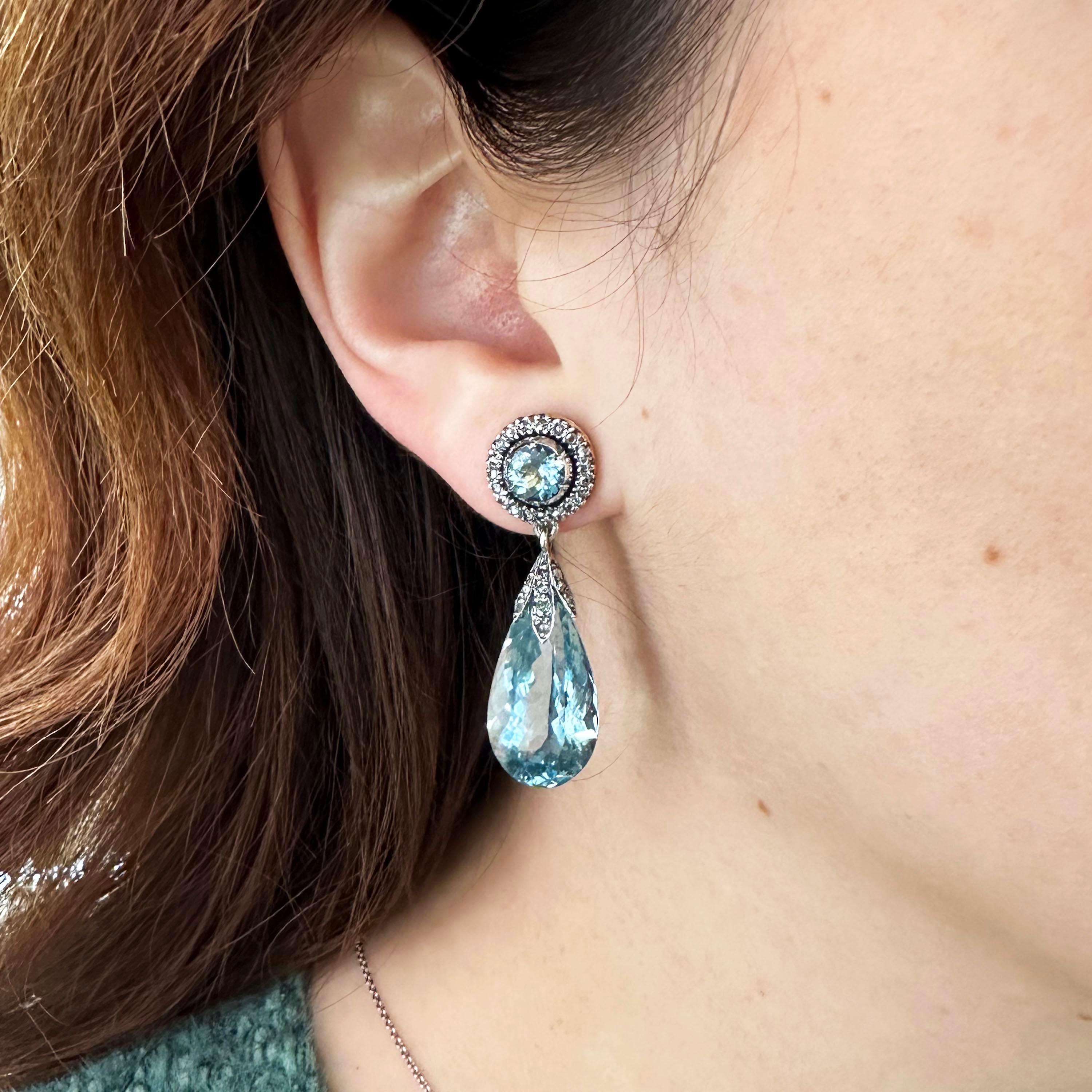 A pair of antique aquamarine and diamond drop earrings, with cluster tops, set with round faceted aquamarines, in cut down settings, surrounded by rose-cut diamonds, in silver claw settings, with pear shape faceted aquamarine pendants, with rose-cut