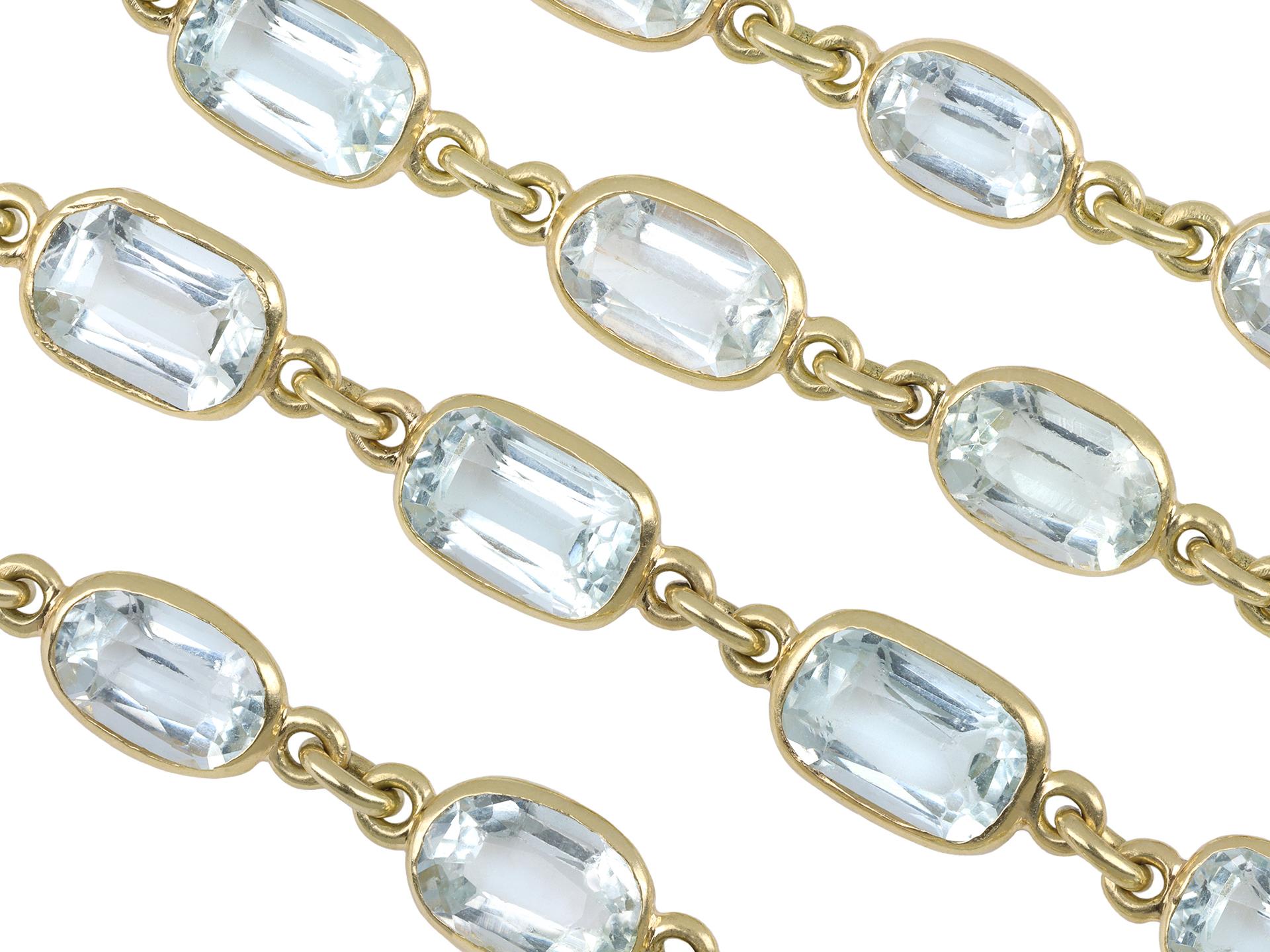 Antique aquamarine necklace. A yellow gold necklace set with one hundred and one cushion shape old cut natural aquamarines in open back spectacle settings with a combined approximate weight of 65.50 carats, to an elegant long guard trace chain,