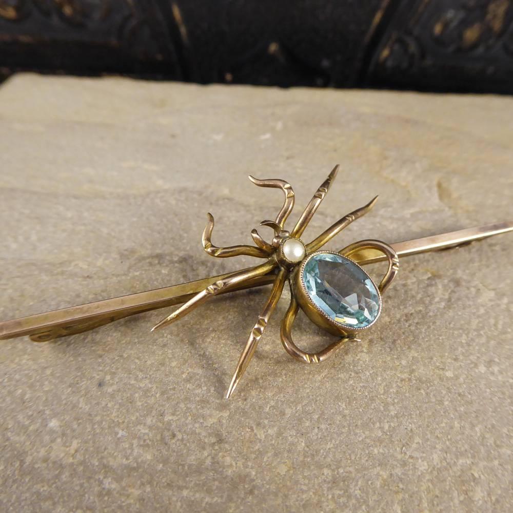 This lovely little 9ct Yellow Gold and metal pin brooch holds a gem set eight legged friend. With an Aquamarine body and Pearl head this isn't your ordinary Spider and would be something you would be happy to have upon your person.

Condition: Very