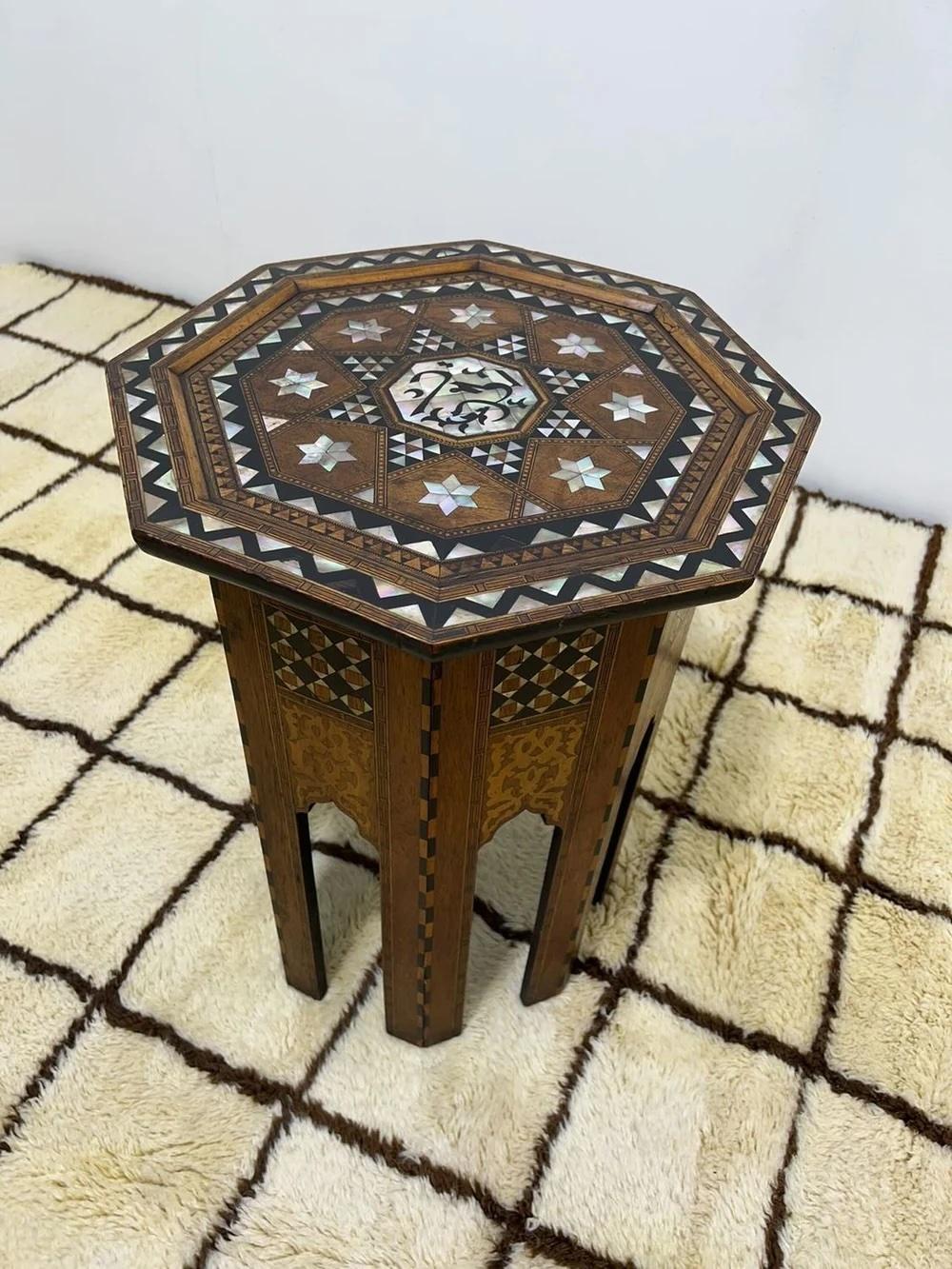 Cette superbe table d'appoint octogonale antique de style moyen-oriental ou marocain présente un magnifique travail d'artisanat dans le style arabe mauresque. Cette table vintage présente un motif géométrique classique avec une alternance