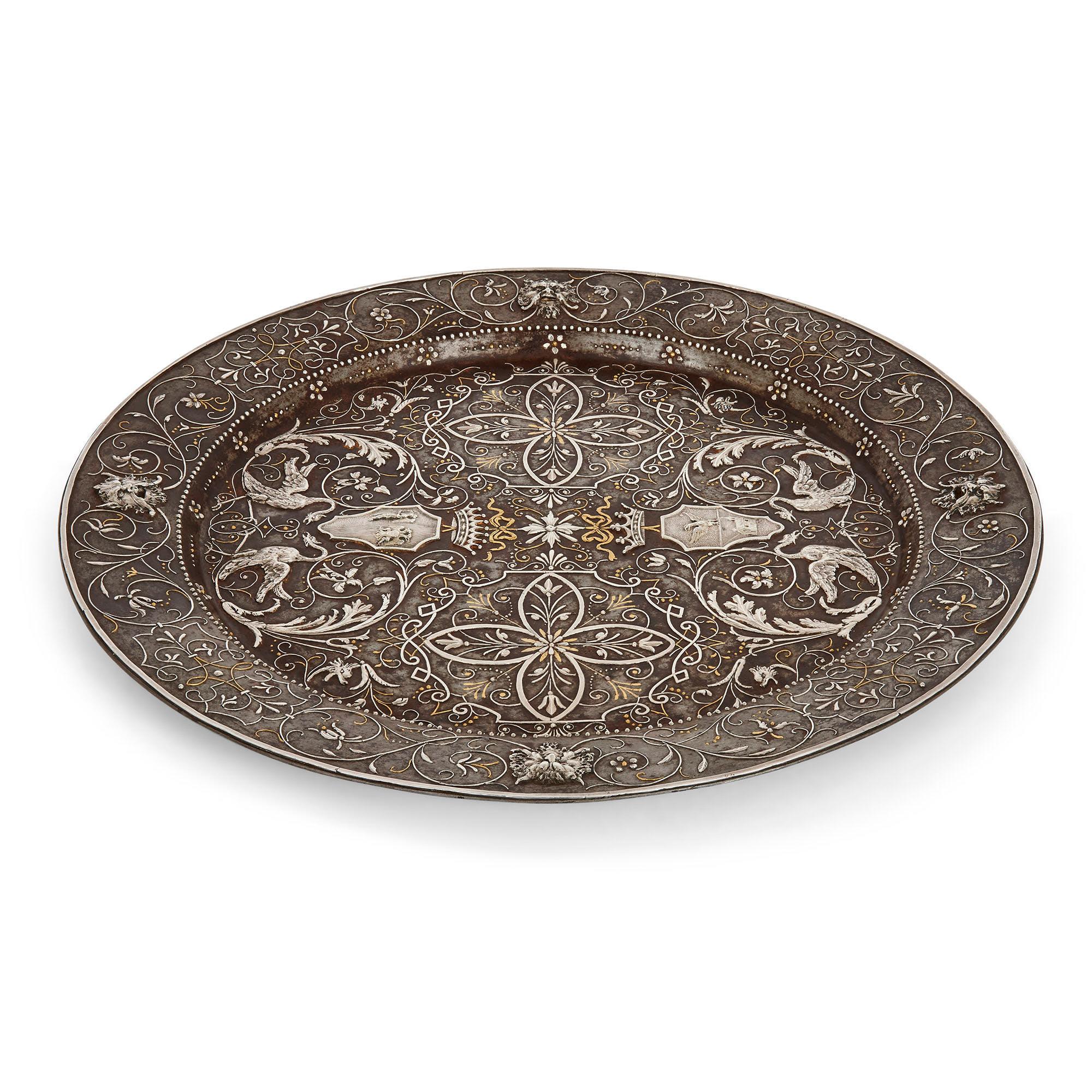 Antique Arabesque steel plate with gold and silver inlay.
Continental, 19th century
Dimensions: Height 2cm, diameter 32.5cm

Beautifully crafted from steel with gold and silver damascening, this fine 19th century plate is profusely decorated