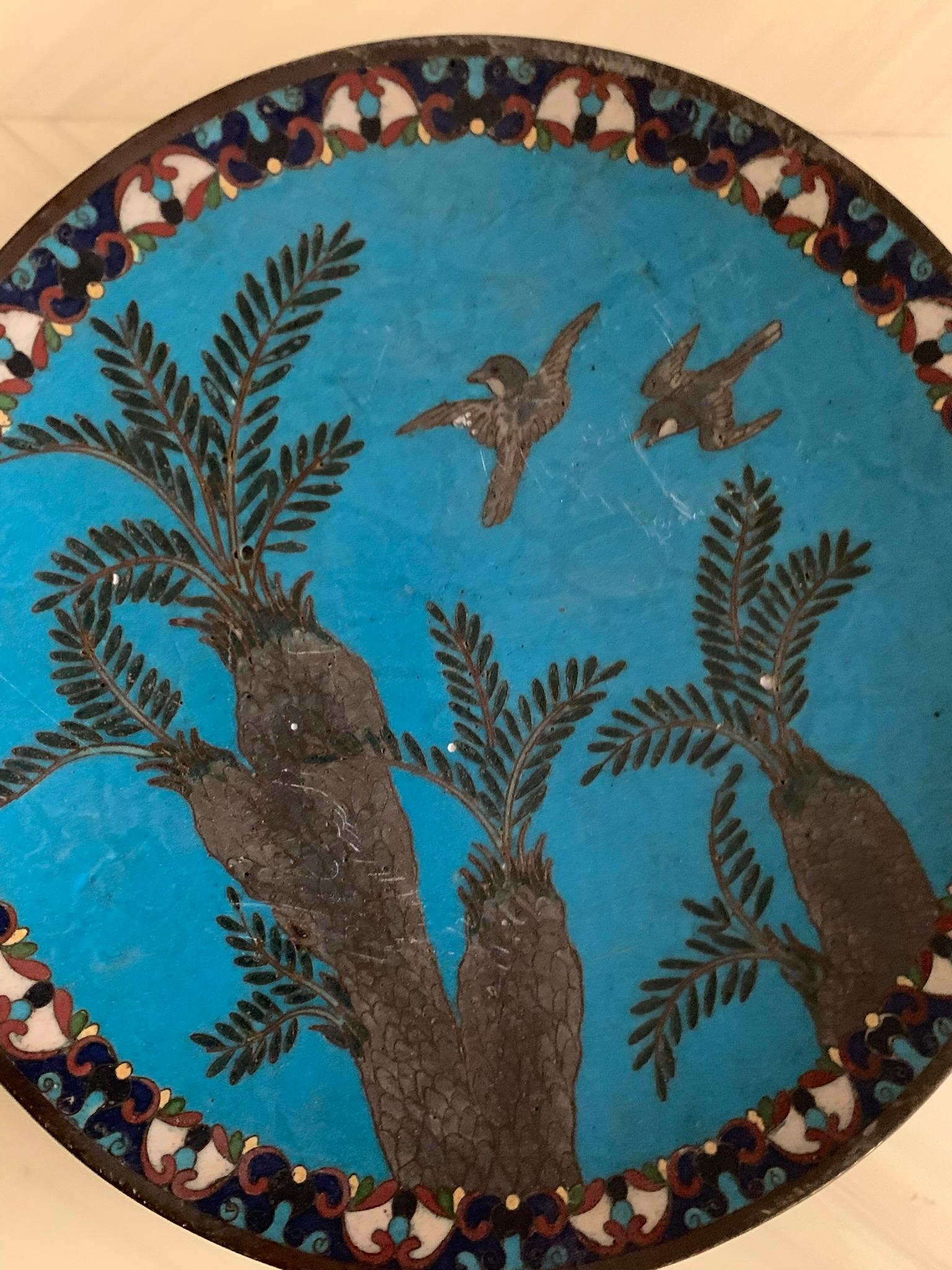 An antique metallic (probably copper) cloisonné plate exquisitely hand-painted in tones of deep turquoise and pewter with accents of burgundy and canary yellow. Depicting palms and sparrows in flight. Possibly from Arabia circa late 19th century.