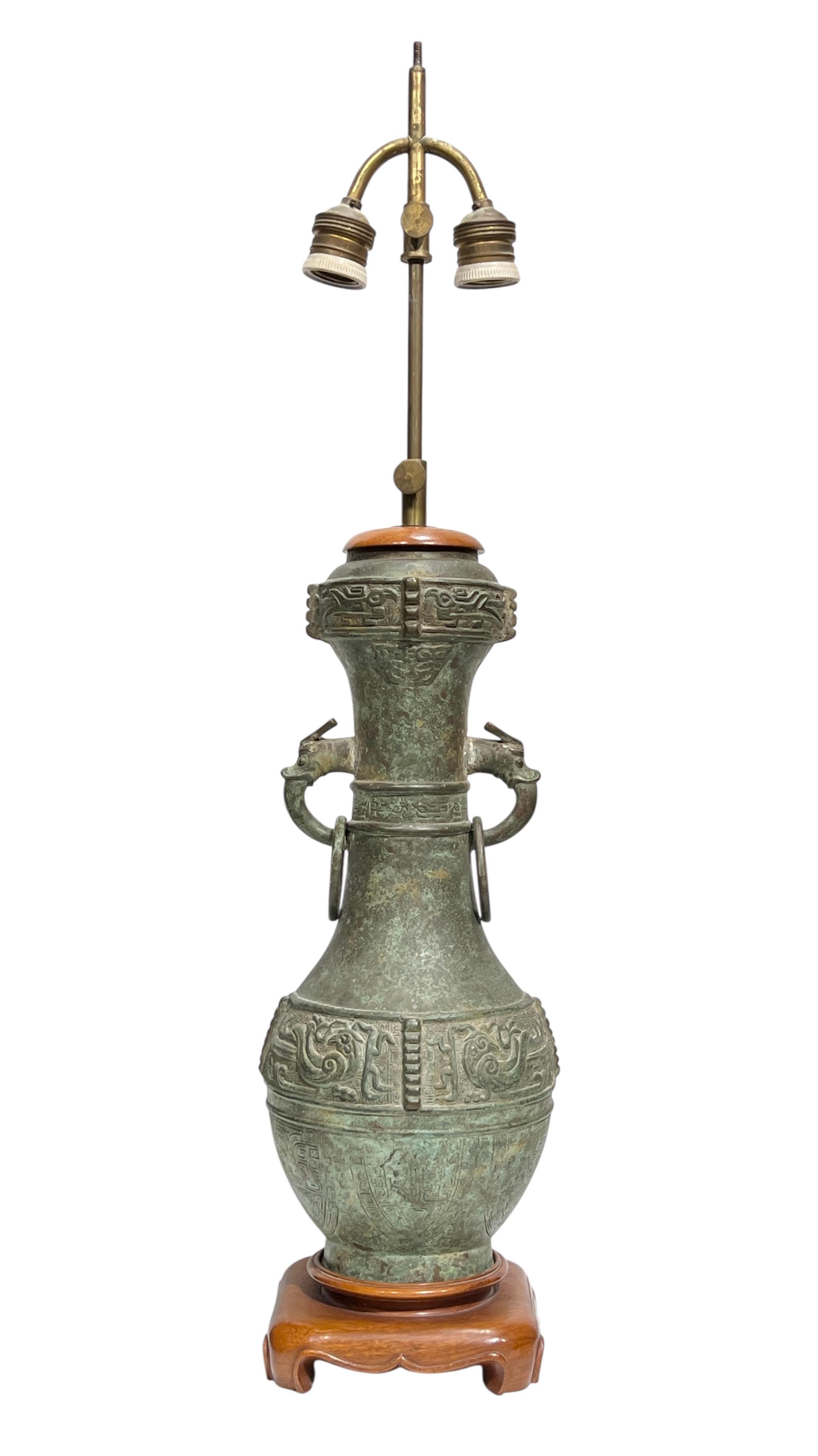 Vaso arcaico cinese in bronzo finemente fuso con patina verdastra e manici ad anello di drago, montato come lampada da tavolo all'inizio del XX secolo con le prese standard originali con diffusori in porcellana bianca, circa 1930.  Con ottone