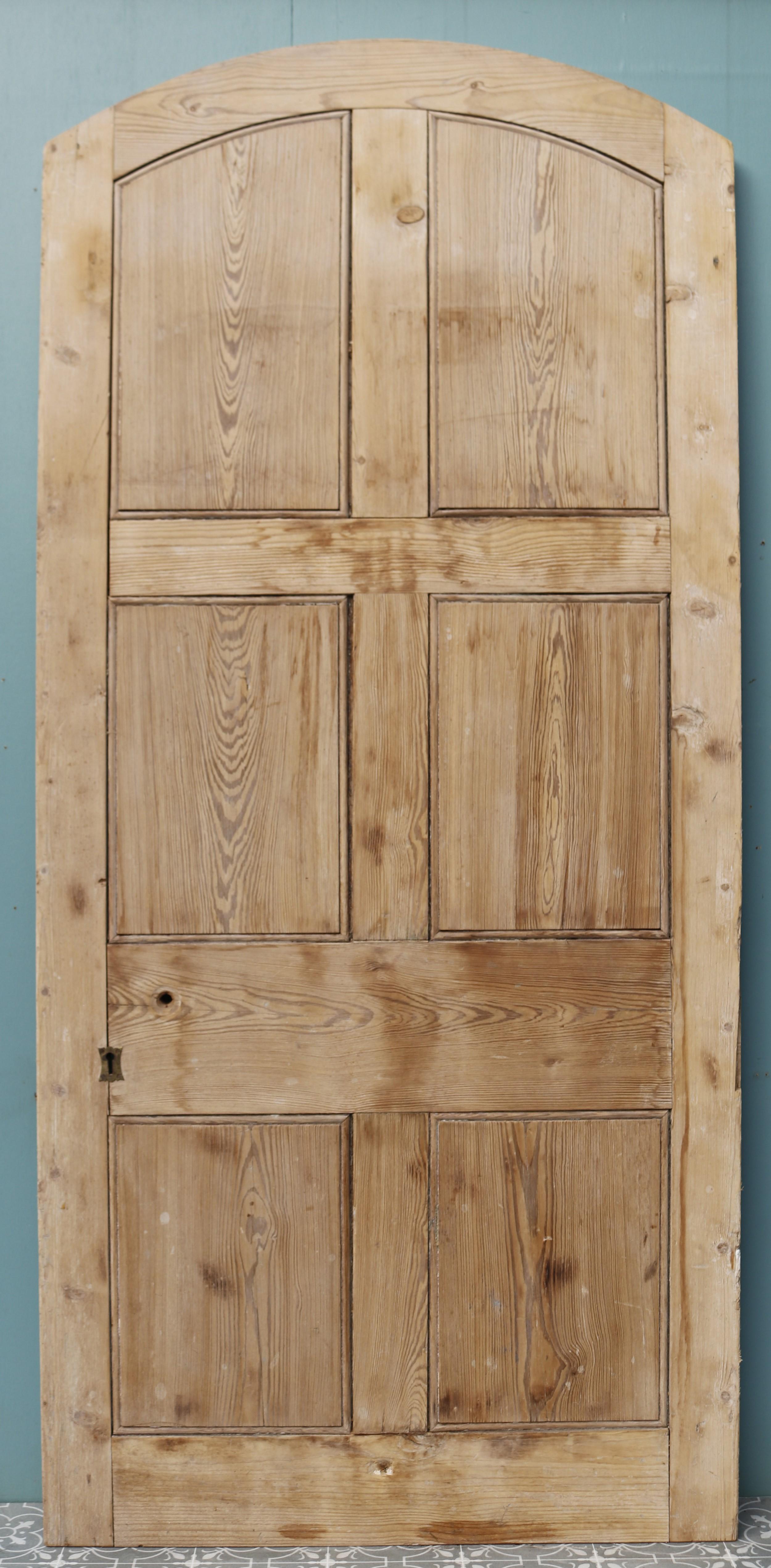 A 19th century reclaimed arched pine door which is suitable for use as a front door.
