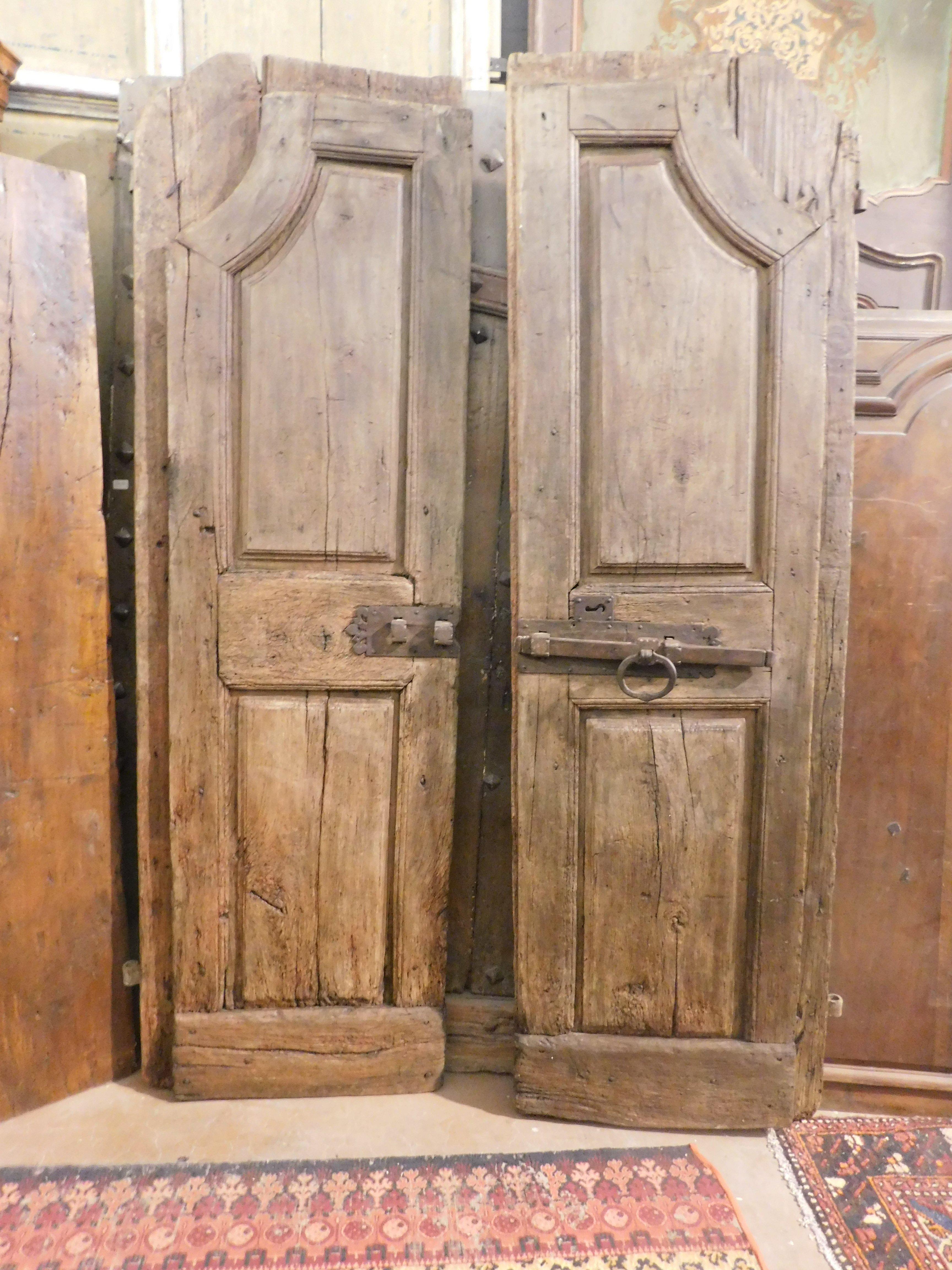 Ancient arched door in solid walnut, hand-carved with arched shape and molared panels, built in the 18th century for a house in northern Italy (Piedmont), has a wide ledge as it opened by pushing and still retains its original ironwork. beautiful