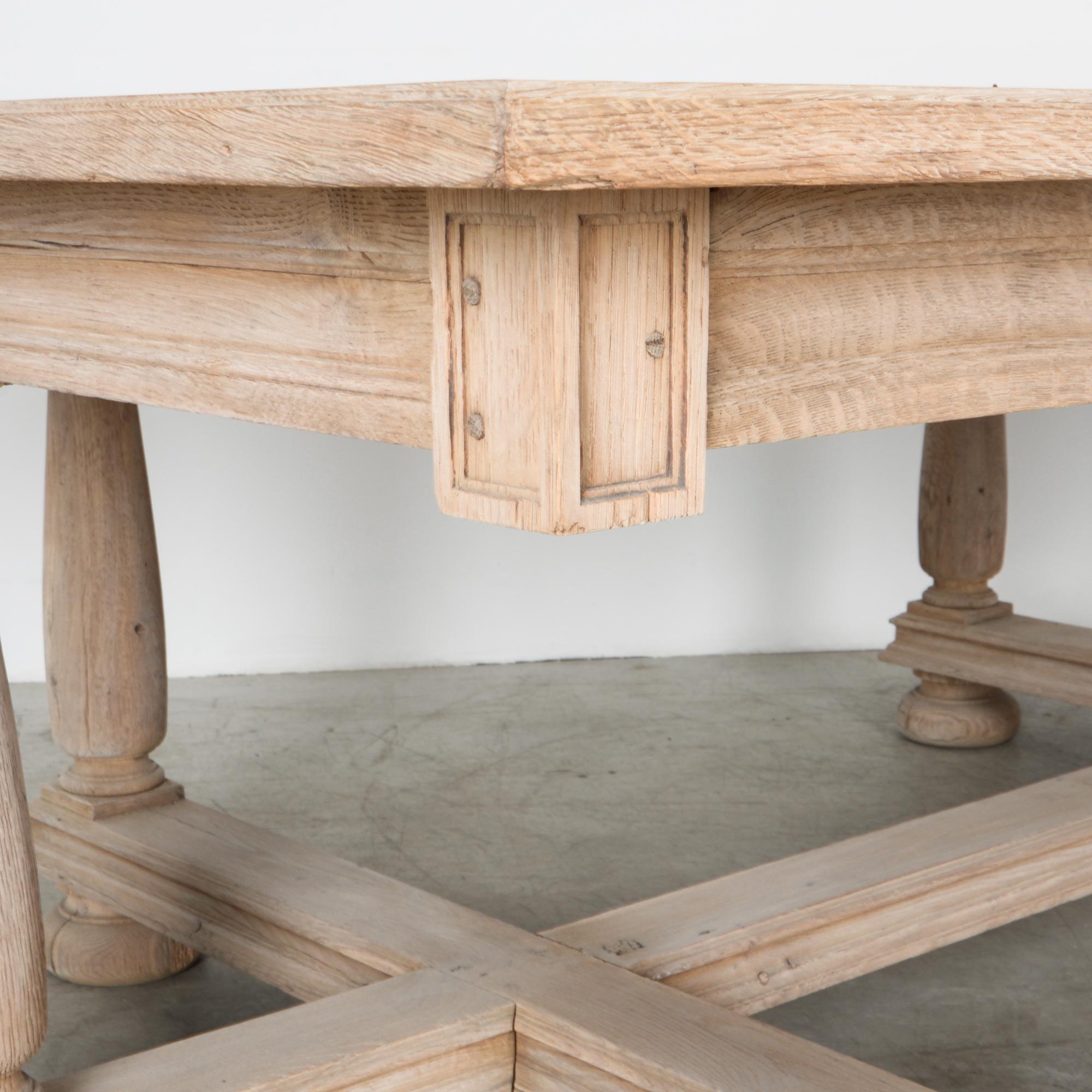 From late 19th century England, an impressive deep dining table in oak. A worn patina gives this piece a great sense of history, enhancing its unique shape. Thick stretchers cross, bracing a configuration of six table legs. Superficial cracks run on