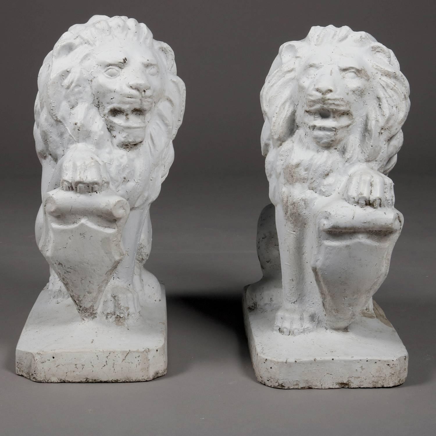 Pair of antique architectural figural concrete flanking driveway or garden gate sculptures of regal guardian lions with shields, 20th century.

Measures: 20