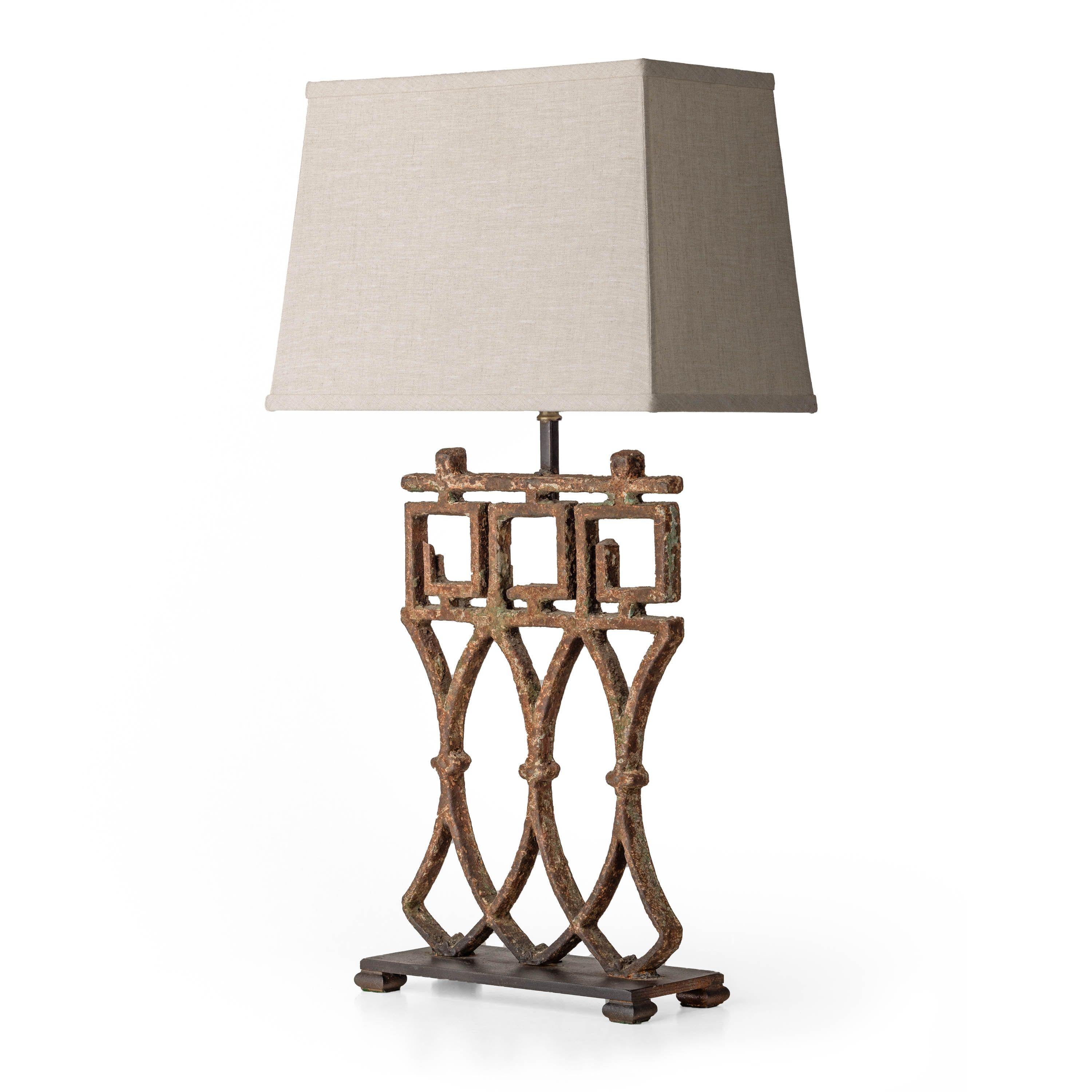 Antique iron gate pieces with original patina paint and aging iron made into table lamps. Greek Key design lends an air of classicism to this substantial pair of lamps, topped by natural linen shades. Narrow depth makes them perfect for a fireplace