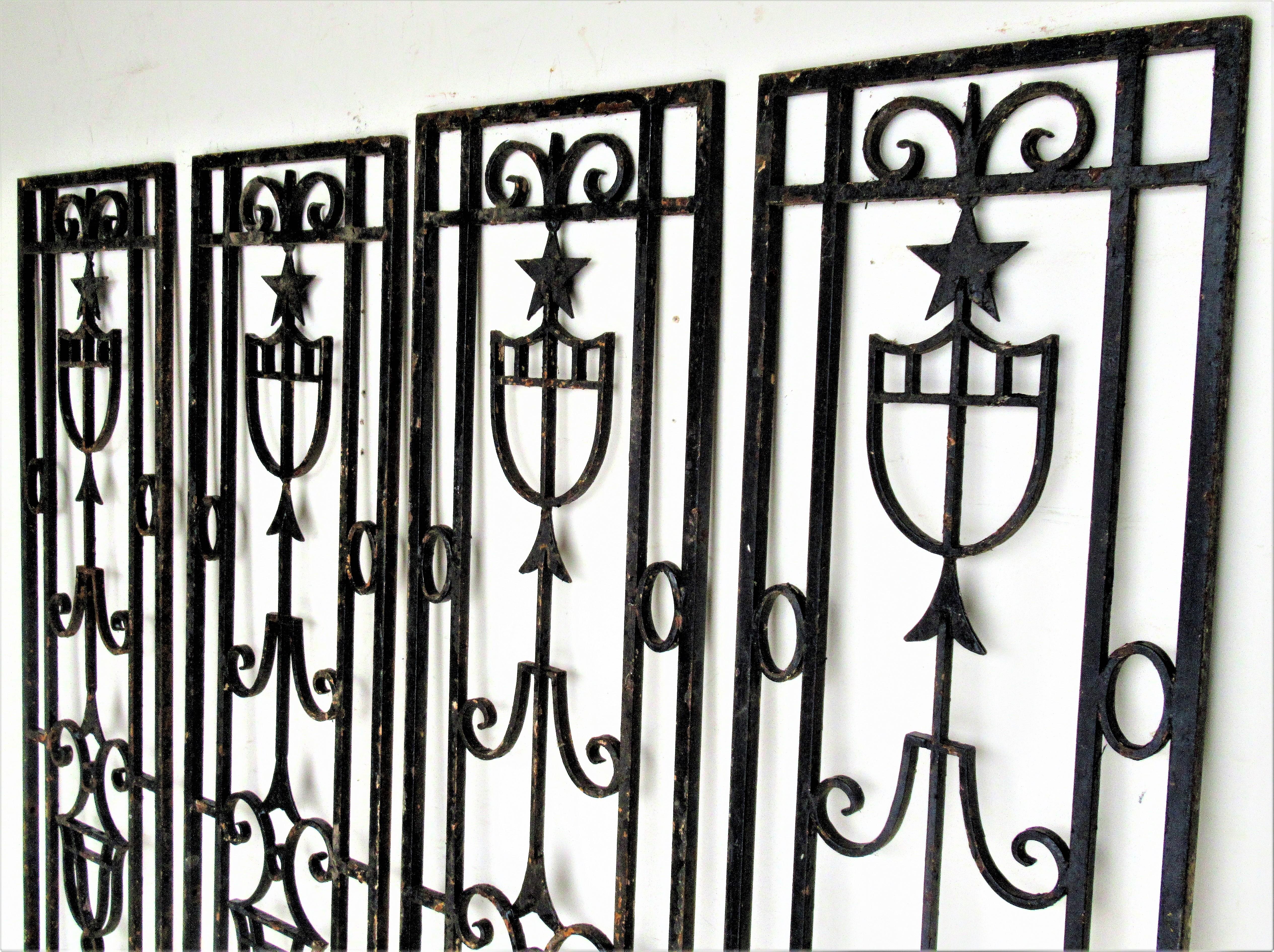A group of four antique tall rectangular architectural iron panels with a hard to find Neoclassic / Directoire design of crossed arrows, stars. shield and urn forms. Circa 1900-1920. Beautiful.
 Look at all pictures and read condition report in