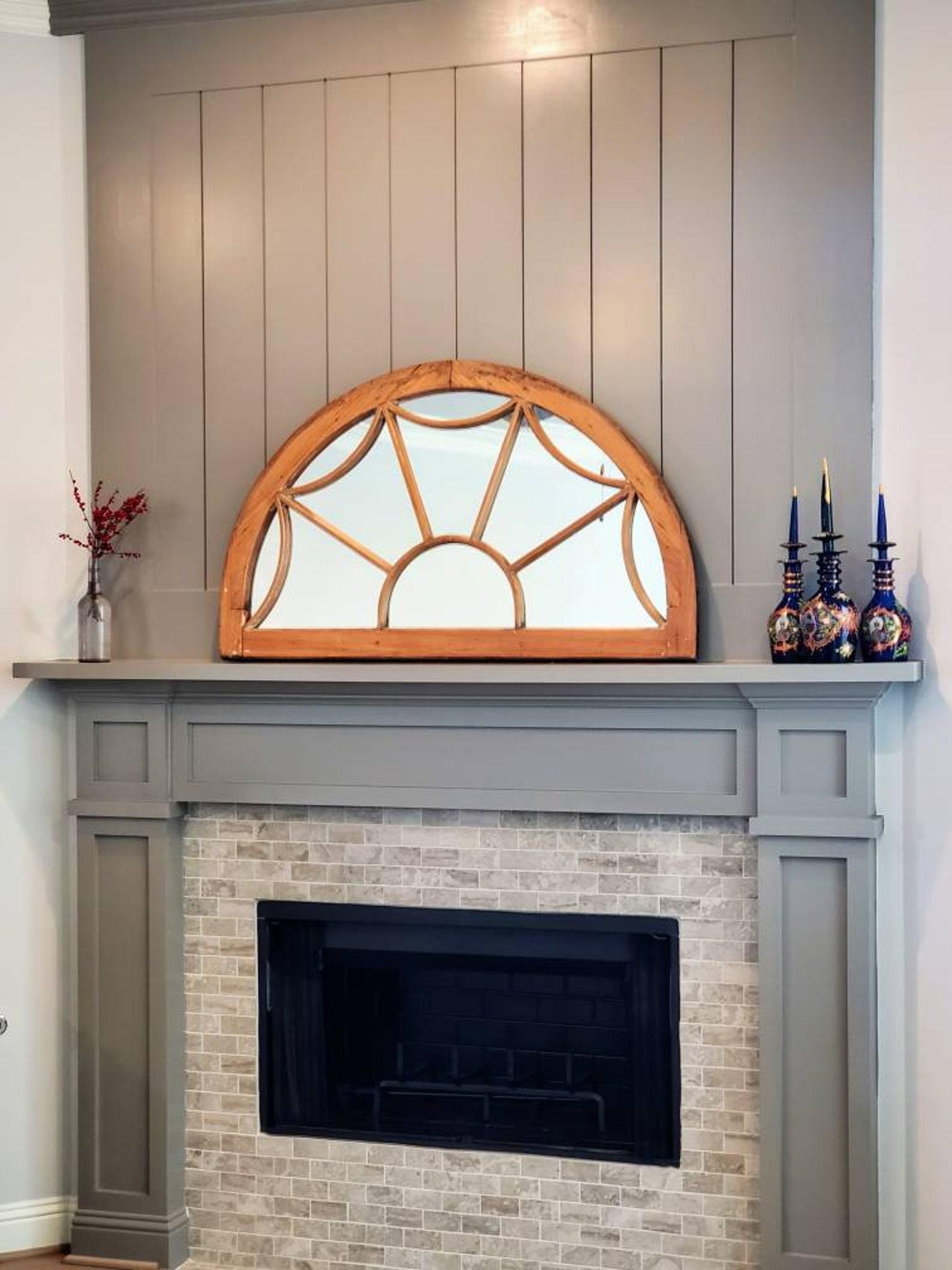An antique architectural transom demilune window repurposed and fashioned as a mirror. The large early 20th century decorative fanlight building element in semi-circular form, with wooden arch, mirrored back and spider web like wooden slat tracery