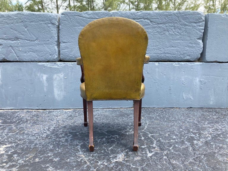 Great antique arm chair with green leather. Wood has some old repairs.