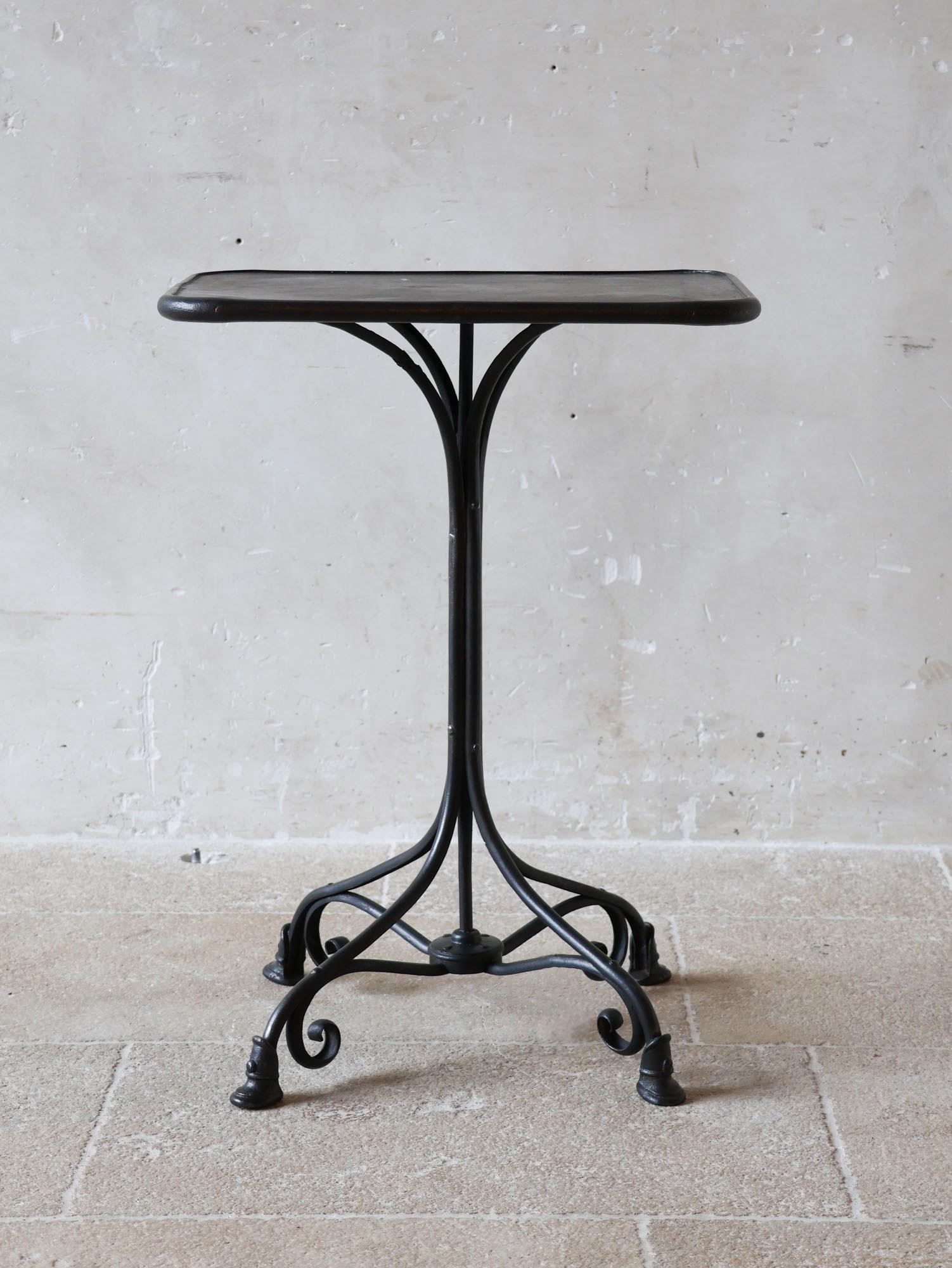 Antique Arras bistro table, crafted from polished wrought and cast iron. This table  features riveted connections and the iconic horseshoe feet characteristic of the Arras style, complemented by the original table top. Made around 1900 in Arras,