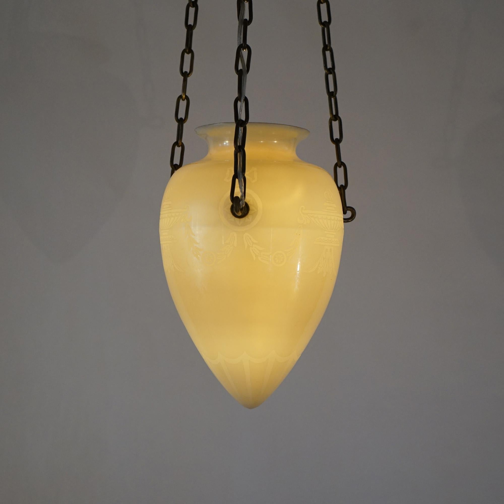 An antique Steuben  pendant light offers calcite art glass construction in tear drop form and having etched Classical design, suspended by three drop chains, c1920

Measures - 33.5