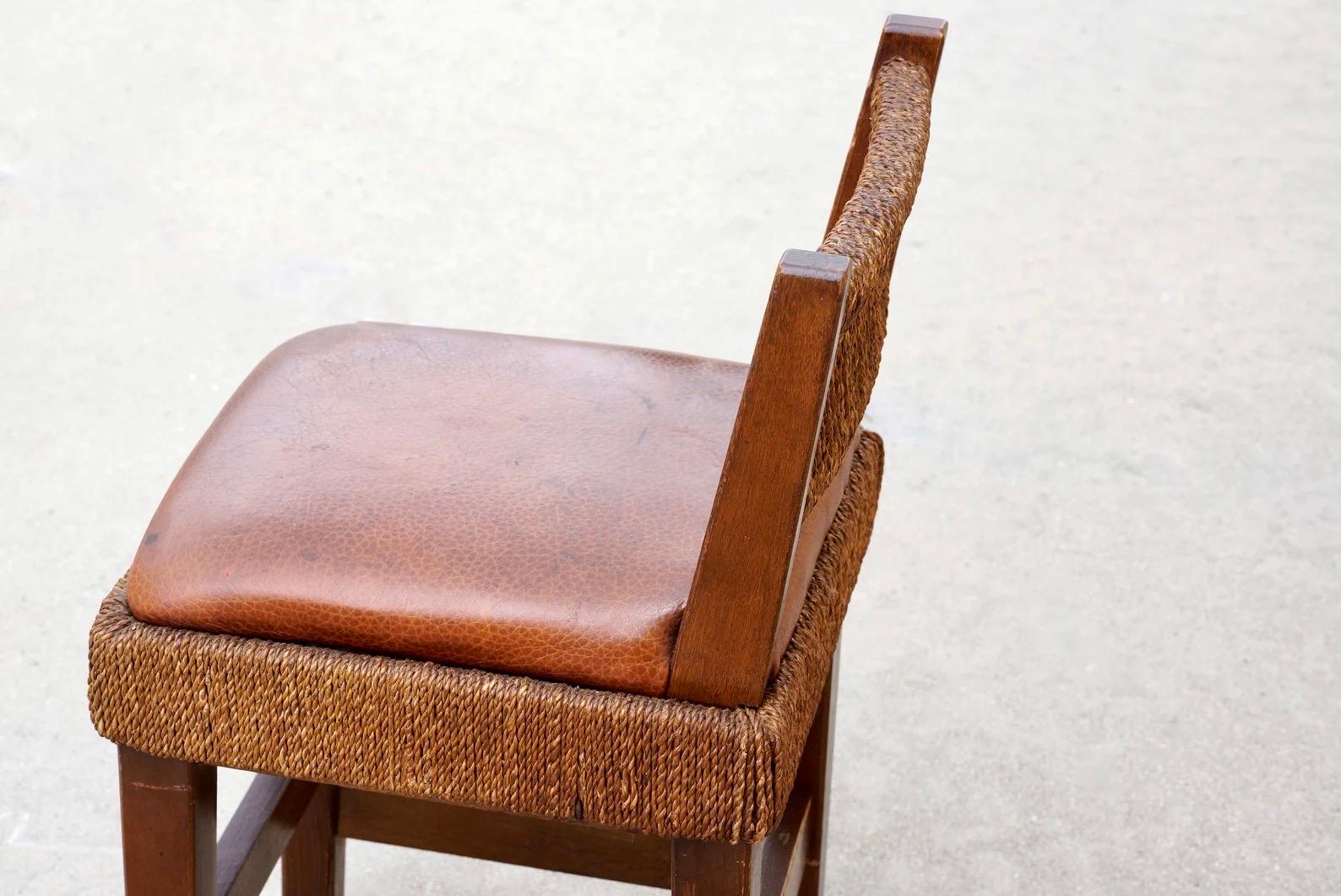 Dieser wunderbare Kinderstuhl im Arts-and-Crafts-Stil besteht aus geflochtenem Binsengeflecht um einen Holzrahmen und einem neu gepolsterten Sitz aus aufgearbeitetem Kieselsteinleder. Es ist in schönem Zustand - strukturell gesund mit einer leichten