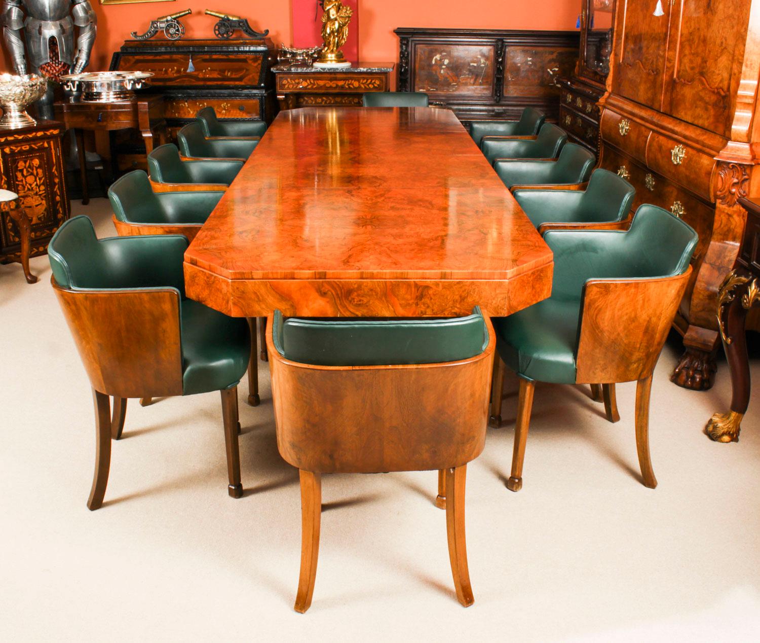A fine rare large Art Deco burr walnut Extending Dining table and twelve matching chairs following a design by Ray Hille, circa 1920 in date.
 
The stunning rectagular top with canted corners has has been hand-crafted from burr walnut, which has a