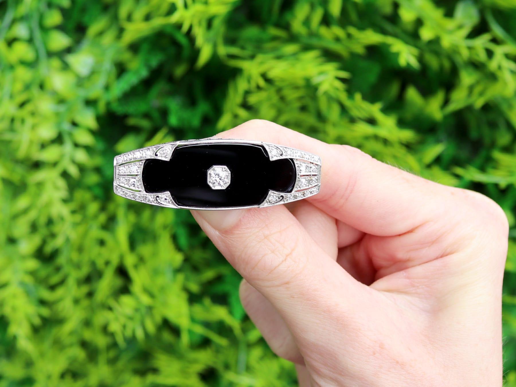 A stunning, fine and impressive antique 11.20 carat black onyx and 0.91 carat diamond, platinum and 15k white gold Art Deco brooch; part of our collection of Art Deco brooches.

This stunning antique black onyx brooch has been crafted in platinum,
