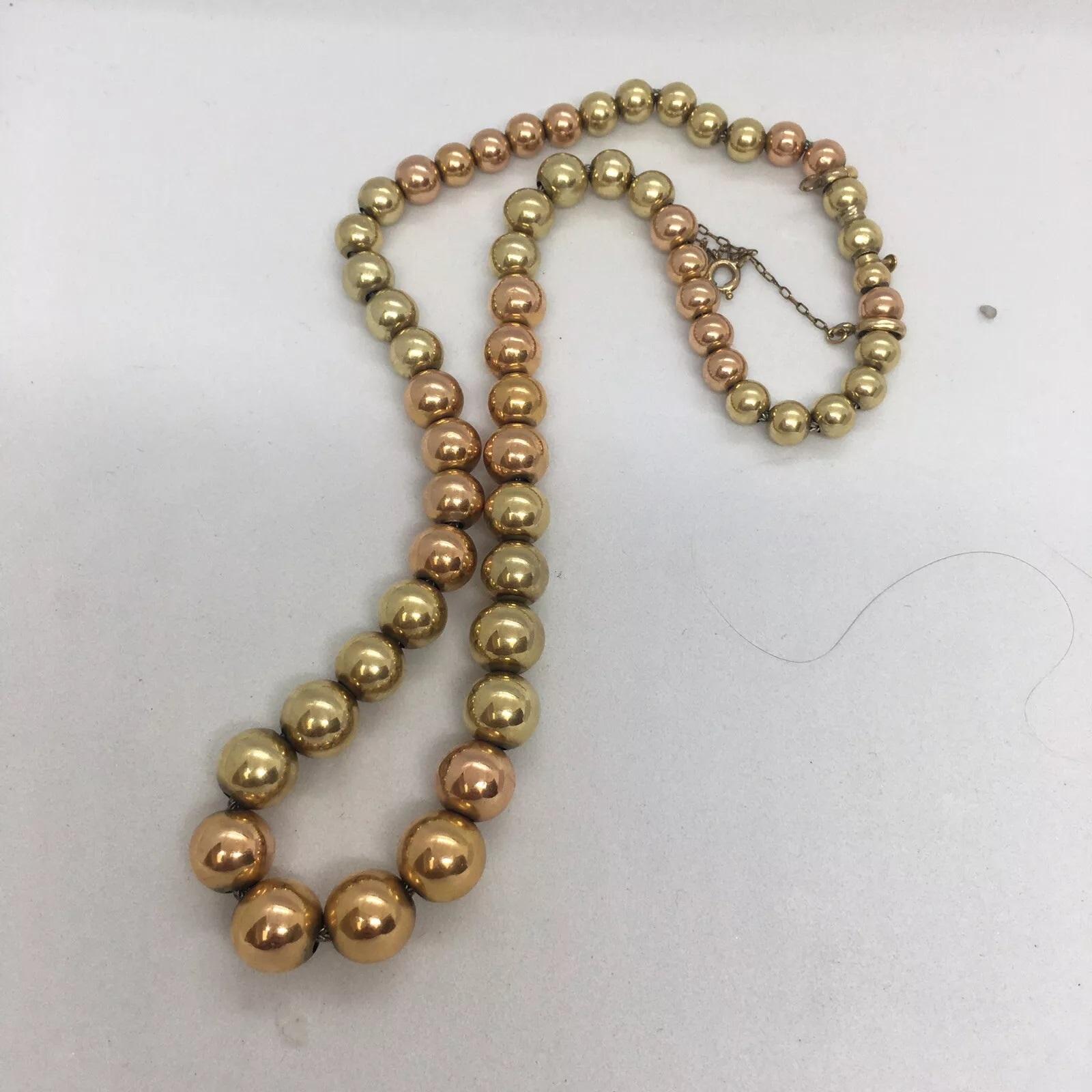 This stunning necklace is a perfect blend of antique and art deco era. Made of 14k yellow gold, it boasts a beautiful bead chain design with a spring ring closure. The necklace is 15.25 inches long and weighs 22.1 grams, making it a perfect