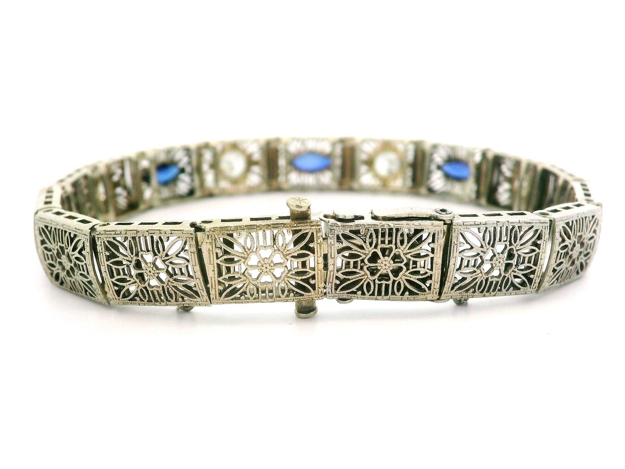 –Stone(s)–
(4) Natural Genuine Diamond - Old European Cut - Pave Set - White Color - 1.0-1.15ctw (approx.)
(2) Synthetic Sapphire - Marquise Cut - Bezel Set - Medium Blue Color - 6.97mm x 2.97mm (approx.)

Material: 14k White Gold
Weight: 14.53
