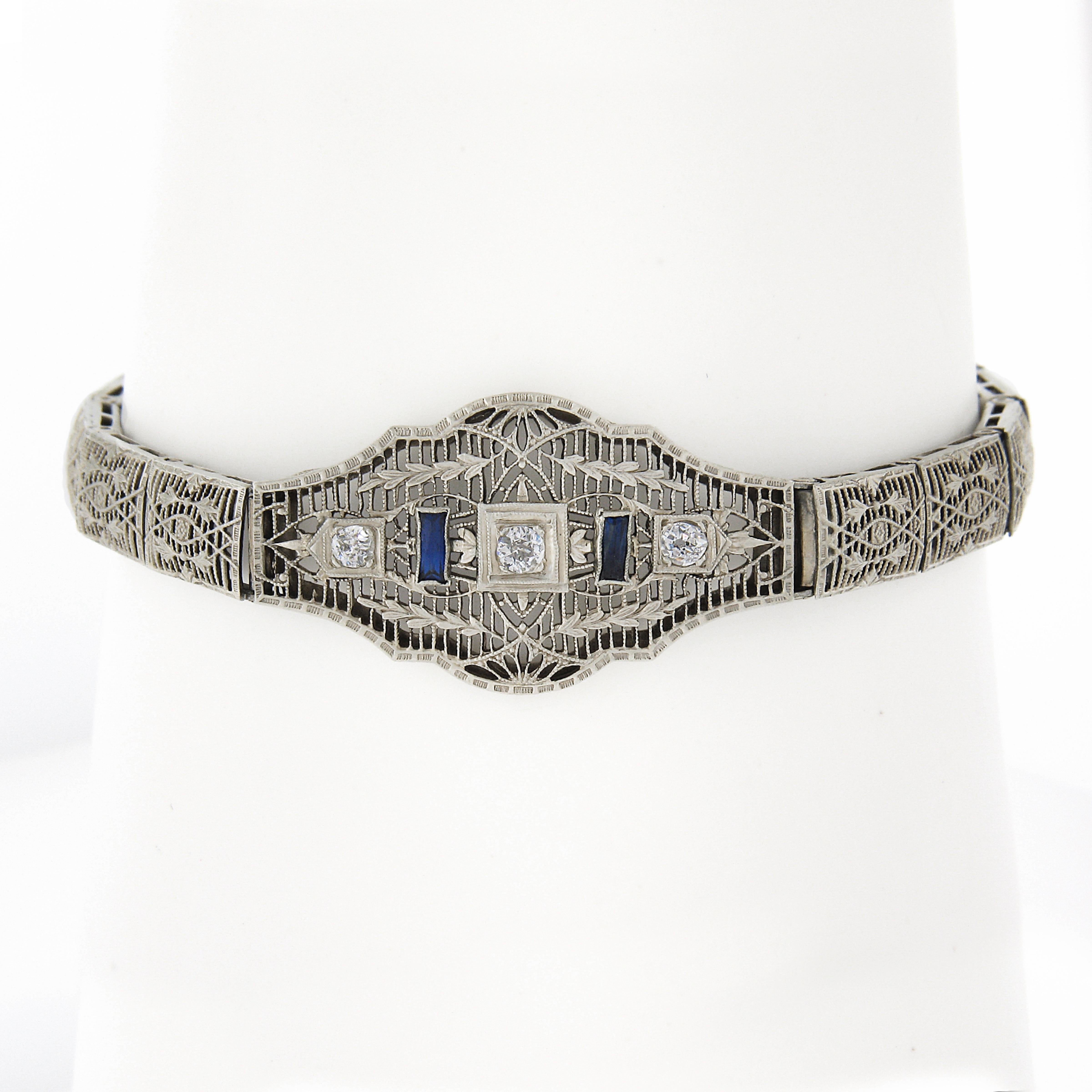 Here we have a truly breathtaking antique bracelet that was crafted from solid 14k white gold during the art deco period, featuring a centerpiece & rectangular links that are all magnificently executed open filigree work & floral patterns & adorned