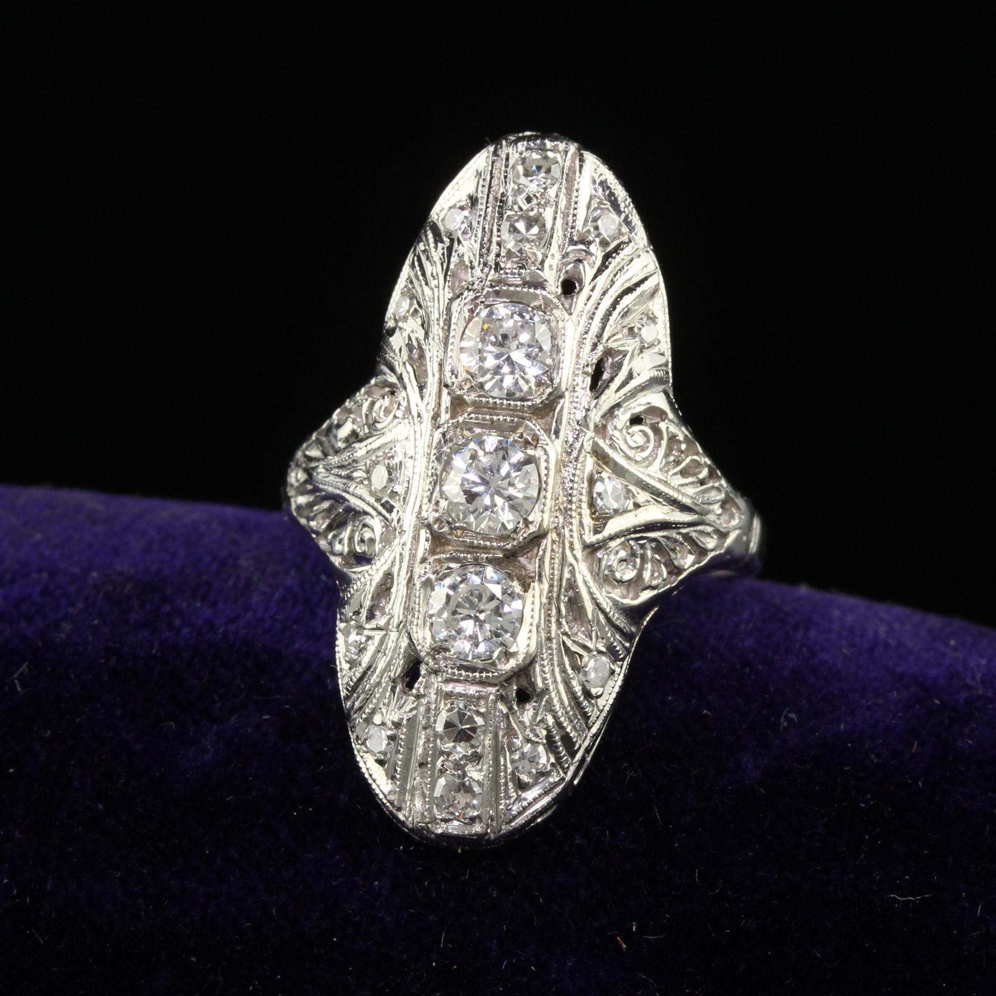 Beautiful Antique Art Deco 14K White Gold Old Cut Diamond Filigree Shield Ring. This gorgeous antique cocktail ring is crafted in 14k white gold. The ring holds beautiful white diamonds on top of the ring and sits low on the finger. The ring is in