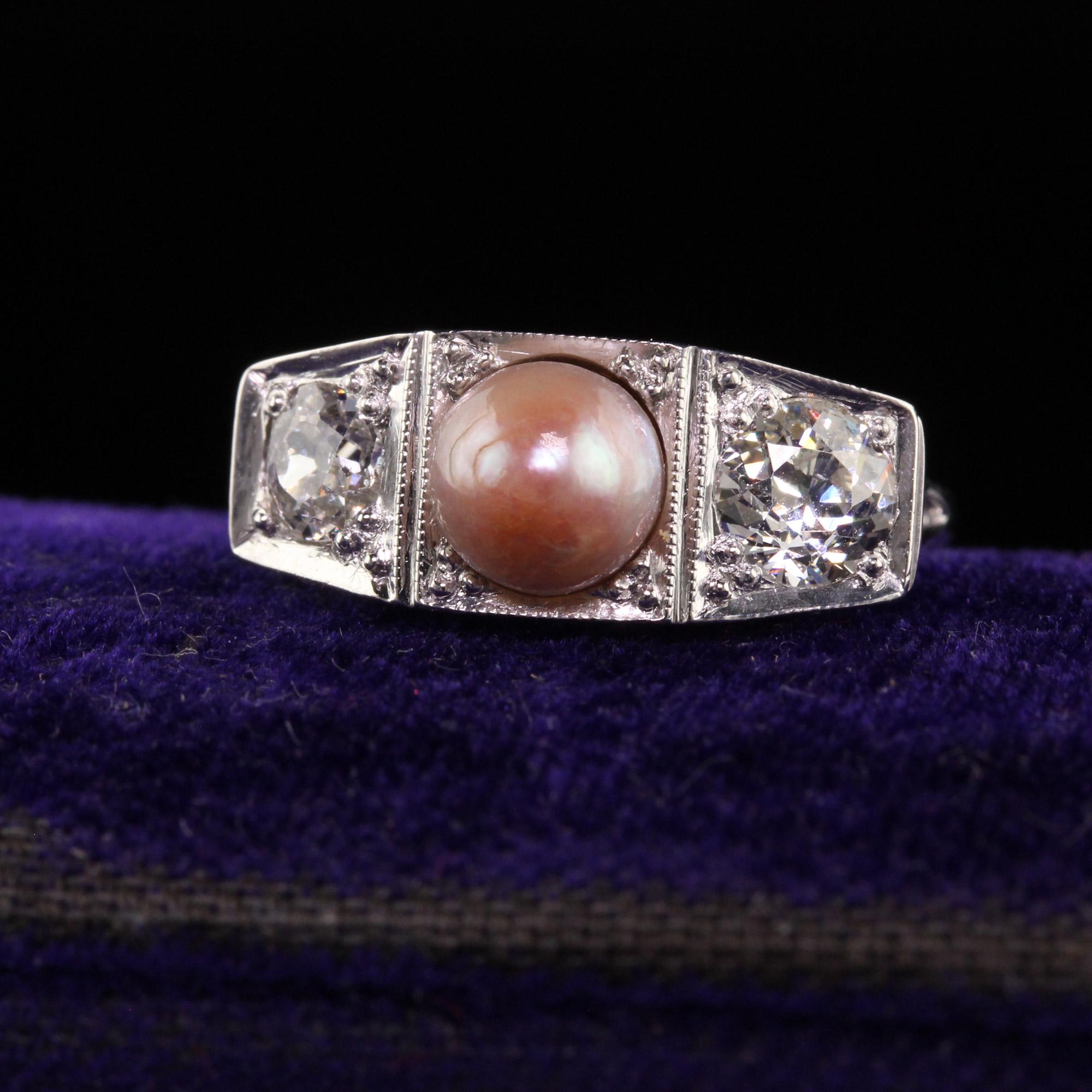 Beautiful Antique Art Deco 14K White Gold Old European Diamond and Pearl Three Stone Ring. This incredible ring is crafted in 14k white gold and platinum top. The center holds a natural pearl with a color that ranges from white to pink. The sides