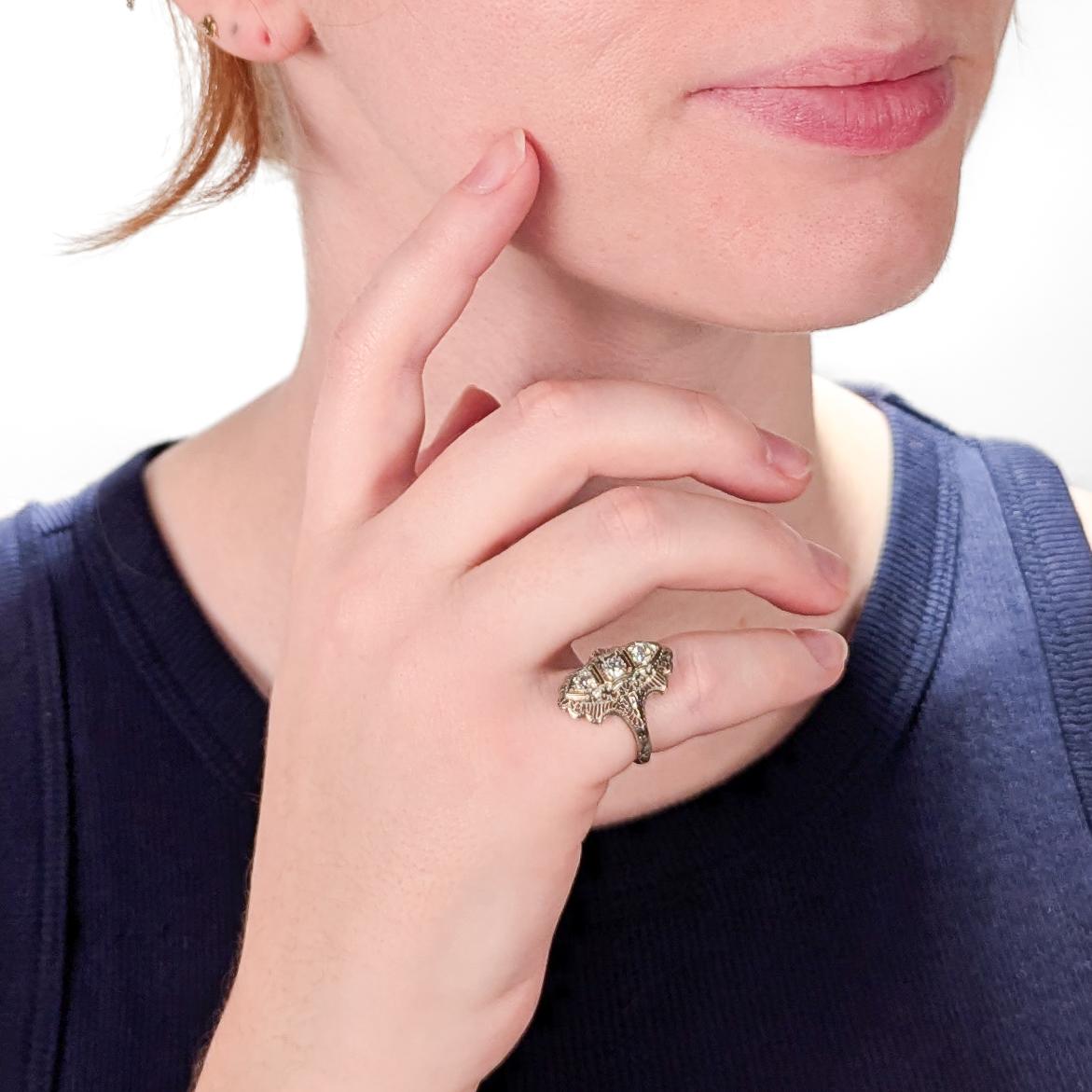 A fine antique Art Deco white gold & diamond ring.

In 14 karat white gold.

With a trio of 3 bezel-set transitional round brilliant cut diamonds in a fine filigree setting with one 3.60mm± diameter diamond flanked on both sides by 3.25mm± diameter
