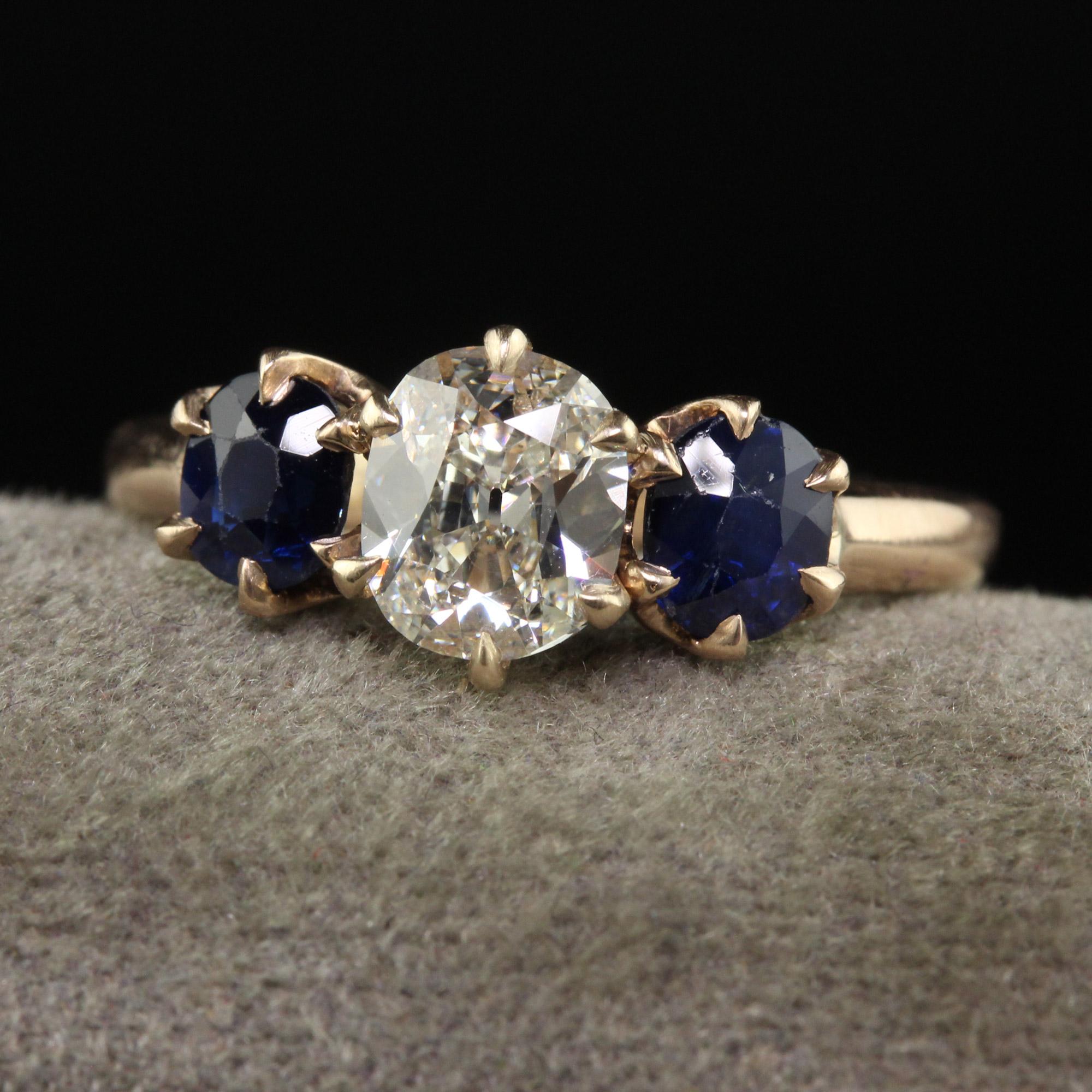 Beautiful Antique Art Deco 14K Yellow Gold Old Cushion Cut Diamond Sapphire Three Stone Ring - GIA. This gorgeous and classic ring is crafted in 14k yellow gold. The center holds a old cushion cut diamond that has a GIA report. The sides are natural