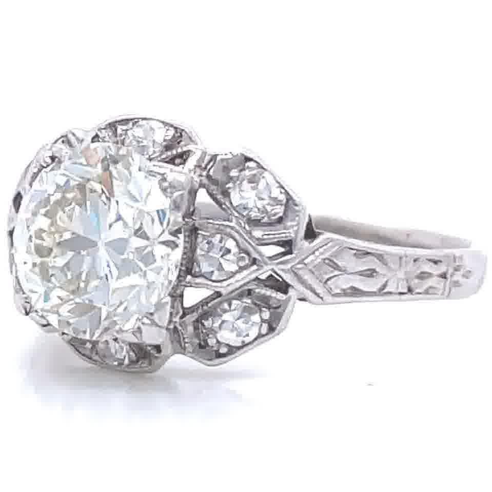 You will love this charming engagement ring with lots of history. It is made for you if you appreciate treasures from the past featuring symmetry and delicacy in the best Art Deco traditions. The main diamond is an Old European Cut approximately