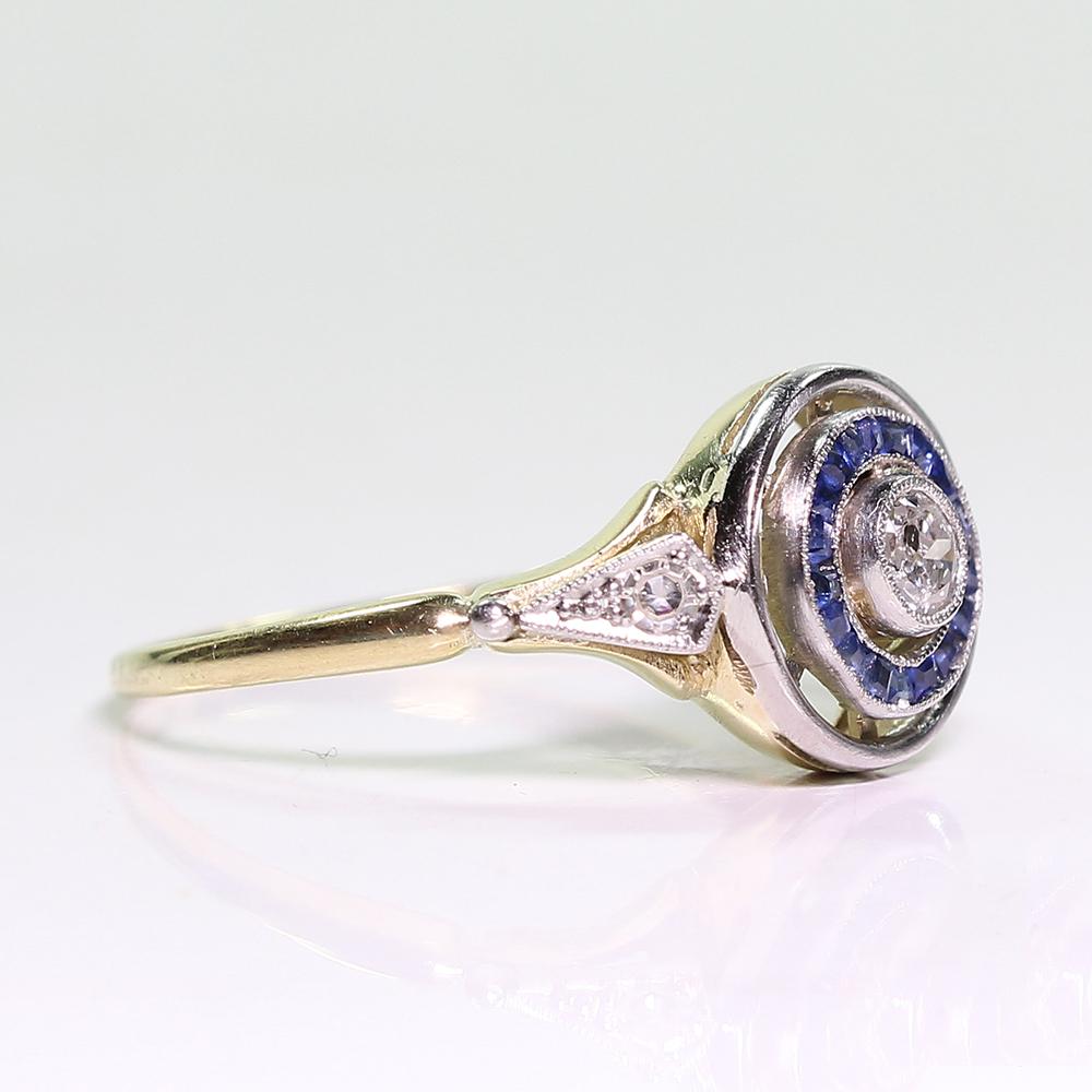 Period: Art Deco (1920-1935)
Composition: 18K gold and Platinum.

Stones:

•	1 Old mine cut diamond of H-SI2 quality that weighs 0.20ctw. 
•	18 natural sapphires that weigh 0.40ctw.
Ring face:  12mm by 10mm 
Rise above finger: 4mm.

This purchase