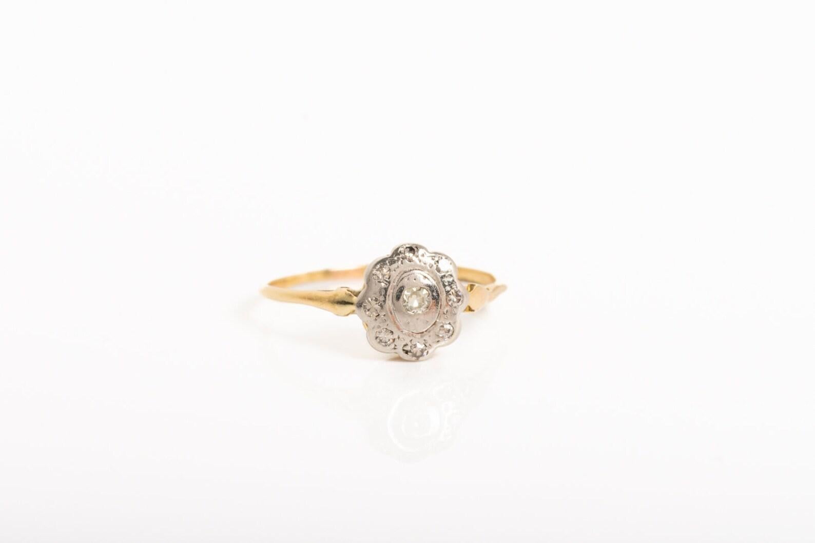 Eine atemberaubende Art Deco Zeitraum 18ct Gold Diamant und Platin Gänseblümchen Ring wurde um 1920. Der Ring aus 18 Karat Gelbgold ist mit neun weißen Diamanten besetzt, die in einer Platinfassung in Gänseblümchenform angeordnet sind. Die Zahl 9