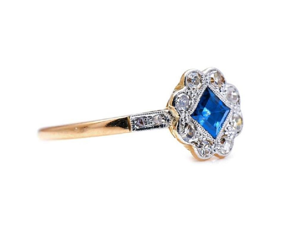 Sapphire and diamond ring, circa 1900. A very pretty square-cut sapphire sits centre of this unusual cluster ring. It resembles the shape of a clover – possibly to resemble the luck of a four-leaf clover. It has two further round diamonds descending