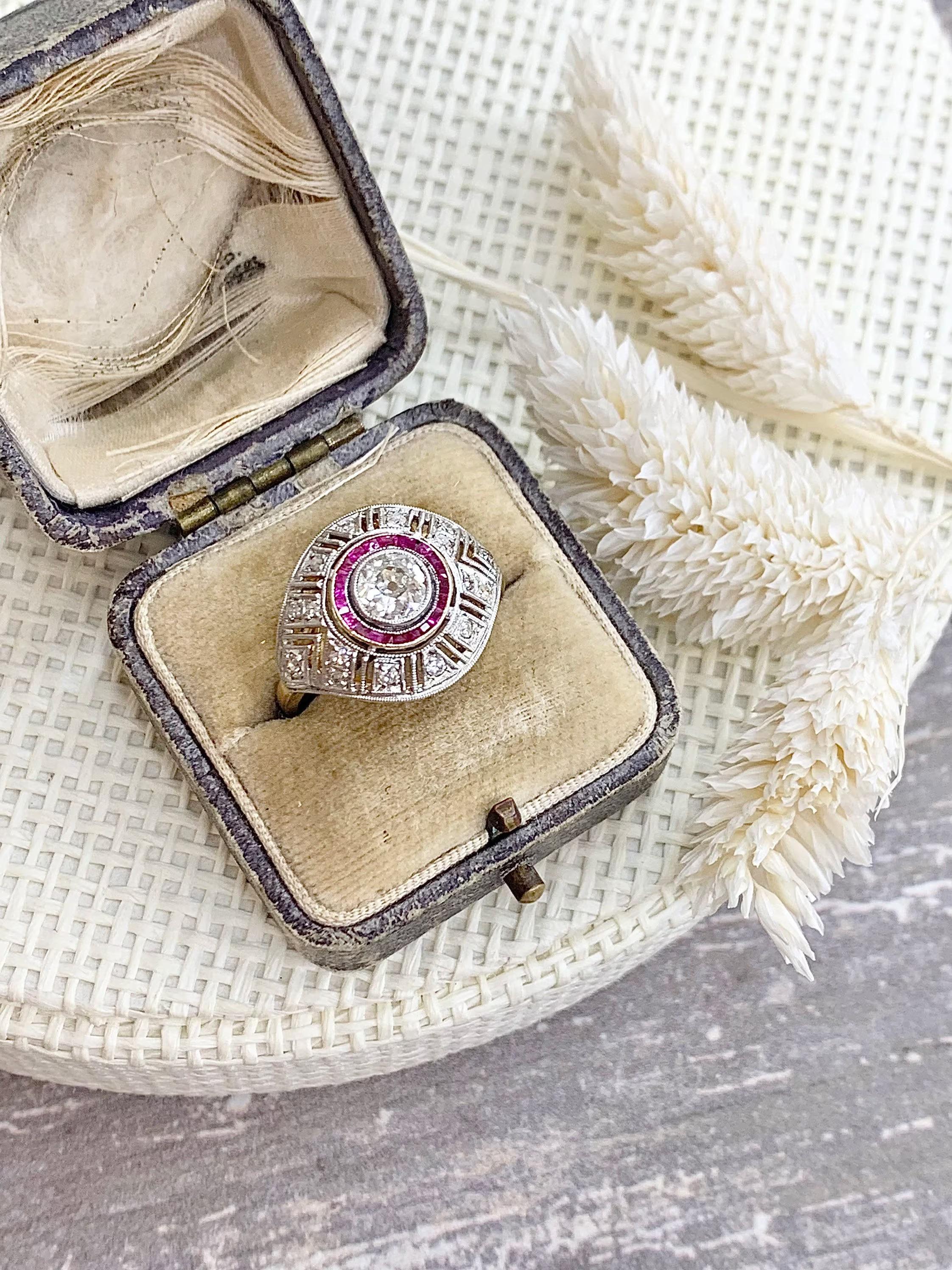 Art Deco Target Ring 

Circa 1920’s

18ct Yellow & White Gold

Set with a Beautiful, Old Brilliant Cut Centre Stone- Approx 0.75cts 
Surrounded in a Target Design of Calibrated Rubies. Complimented Beautifully with Old Cut Diamonds in a Bombe