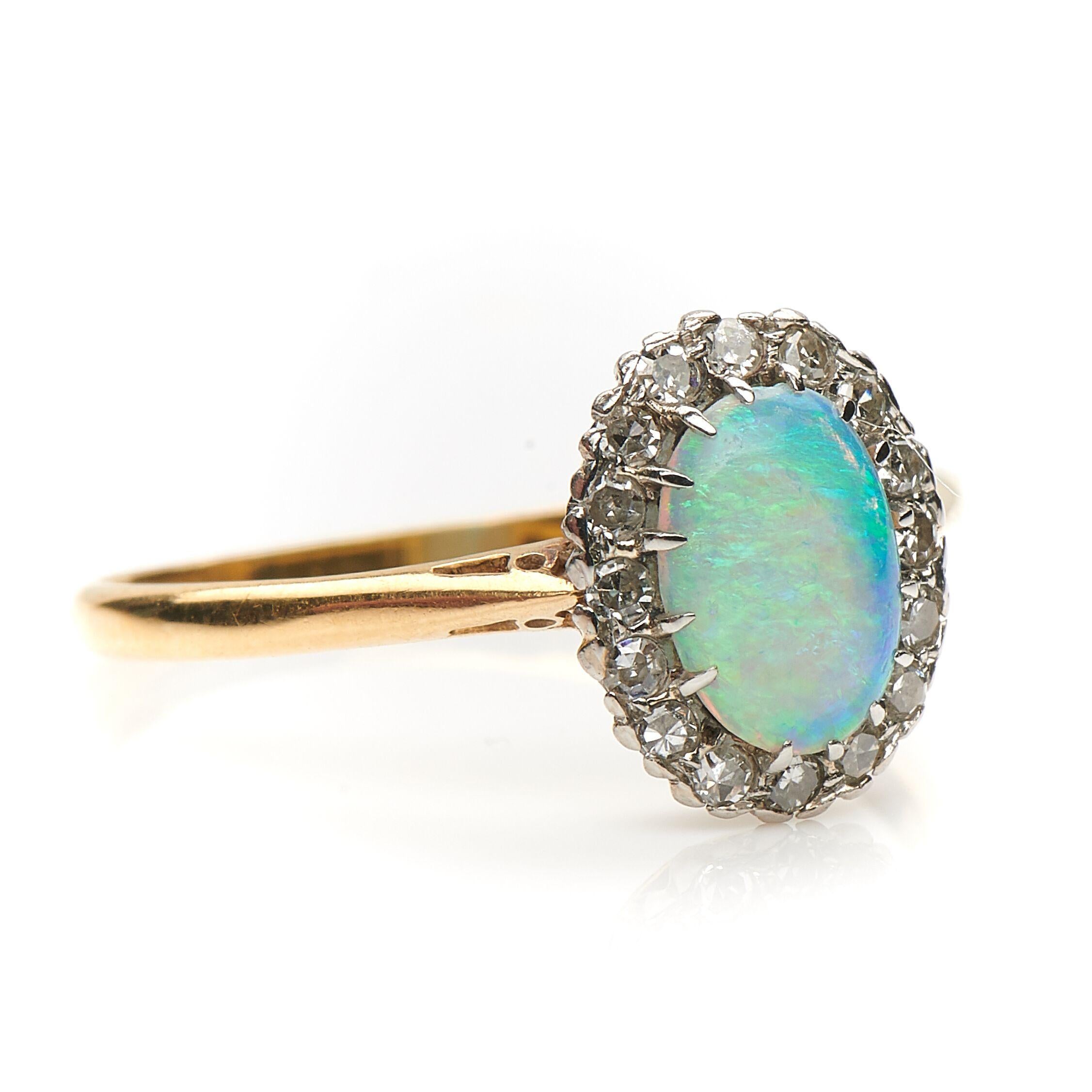 Early Art Deco, opal and diamond cluster ring, circa 1915. Set to centre a wonderful vibrant opal in a mixture of green and blue tones framed by a boarder of delicate single cut diamonds in a platinum and 18ct yellow gold setting. The opal has an