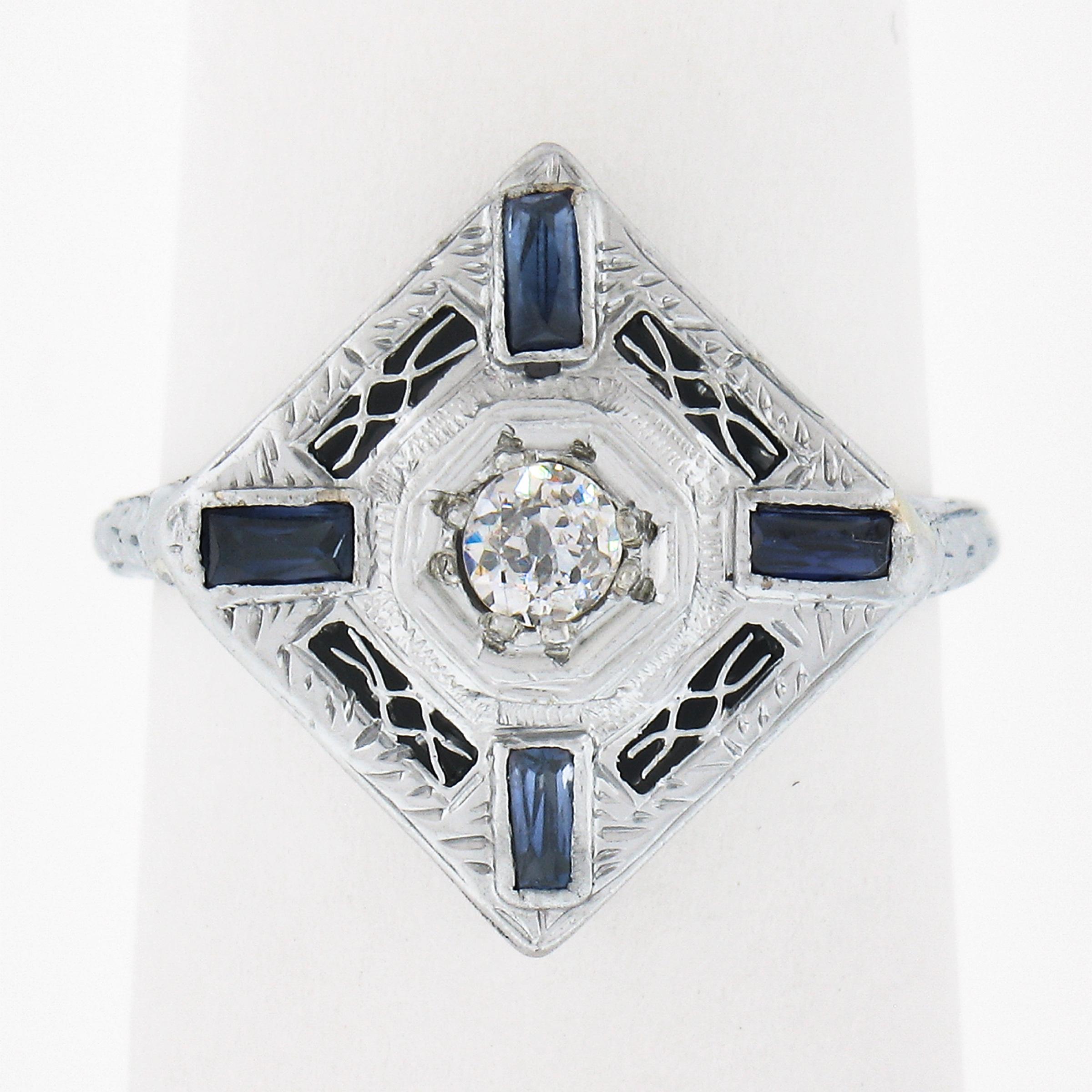 This beautiful, antique art deco dinner ring was crafted in solid 18k white gold and remains crisp with its engraving and filigree work intact. The unique platter design is adorned with open filigree work and is set with synthetic sapphires and an