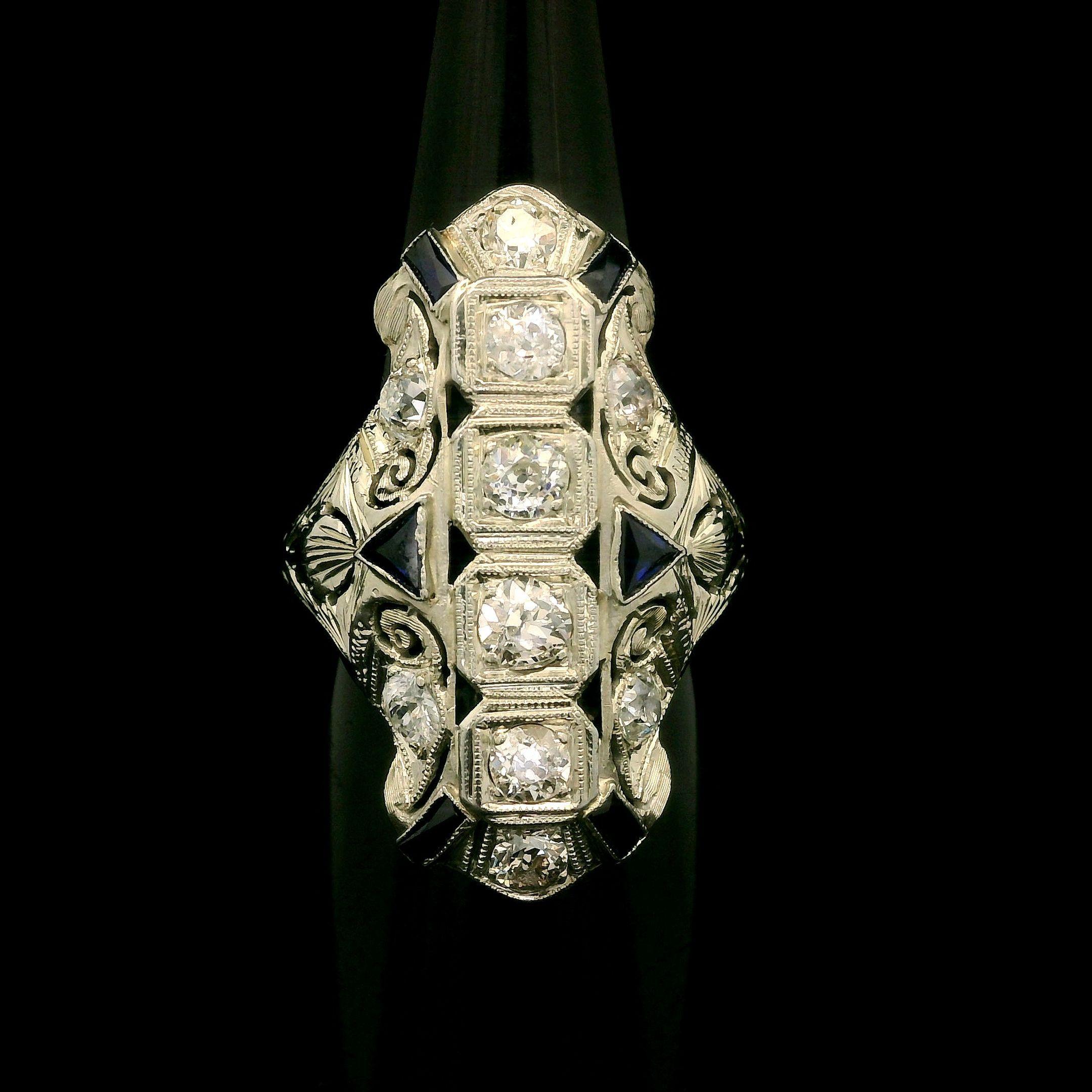 --Pierre(s) :...
(10) Diamants naturels authentiques - taille européenne ancienne - sertis - pureté SI2-I2 - couleur H-J - 1,25ctw (approx.)
(6) Saphirs synthétiques - Trillion & Baguette Cut - Bezel Milgrain Set - Blue Color

MATERIAL : Or blanc