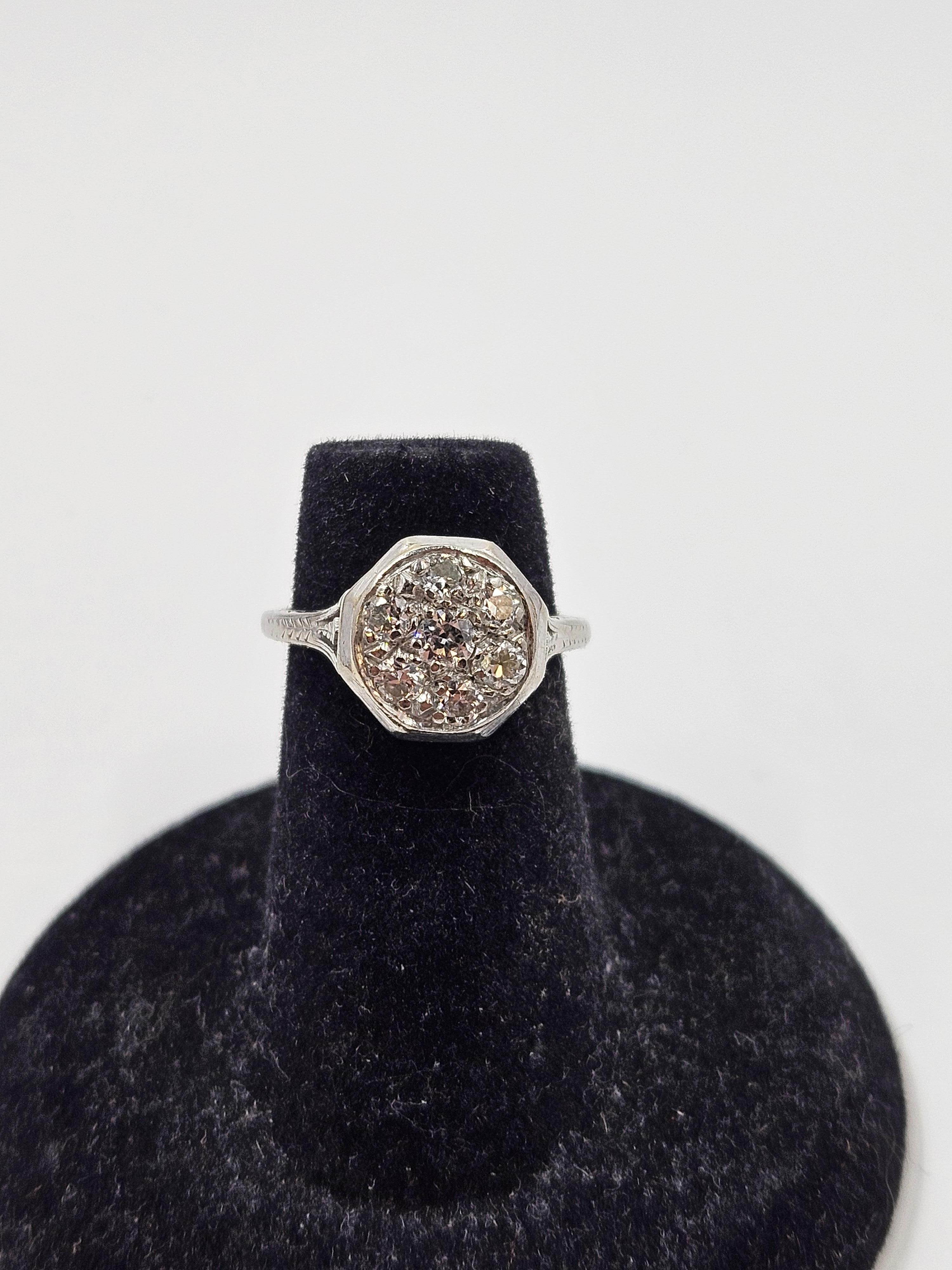 Antique art deco 18K white gold diamond daisy cluster ring. Size 3.75. Features 7 3mm diamonds. The ring weighs 3.3 grams and has an 11mm head. There is minimal finish loss. Wear is consistent with age and use. The diamonds appear to be very clear