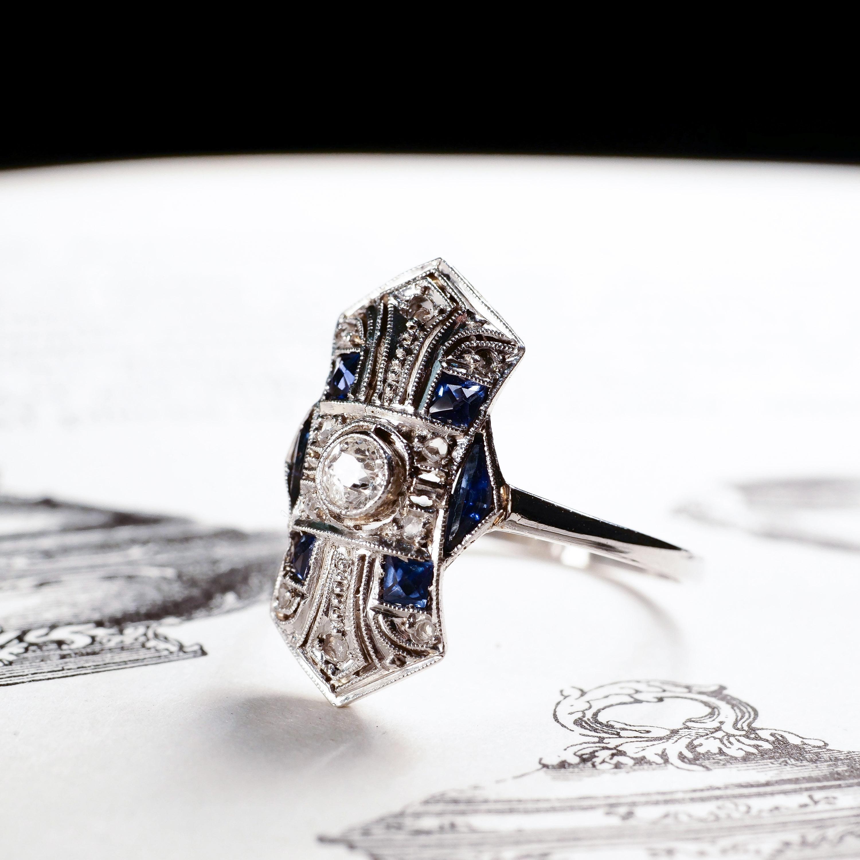 Wir freuen uns, diesen atemberaubenden antiken Diamant- und Saphirring im Art Deco-Stil anbieten zu können.
 
Schon auf den ersten Blick hebt sich dieser Ring durch seine Ästhetik und sein Deko-Design von der Masse ab und bietet ein bemerkenswertes