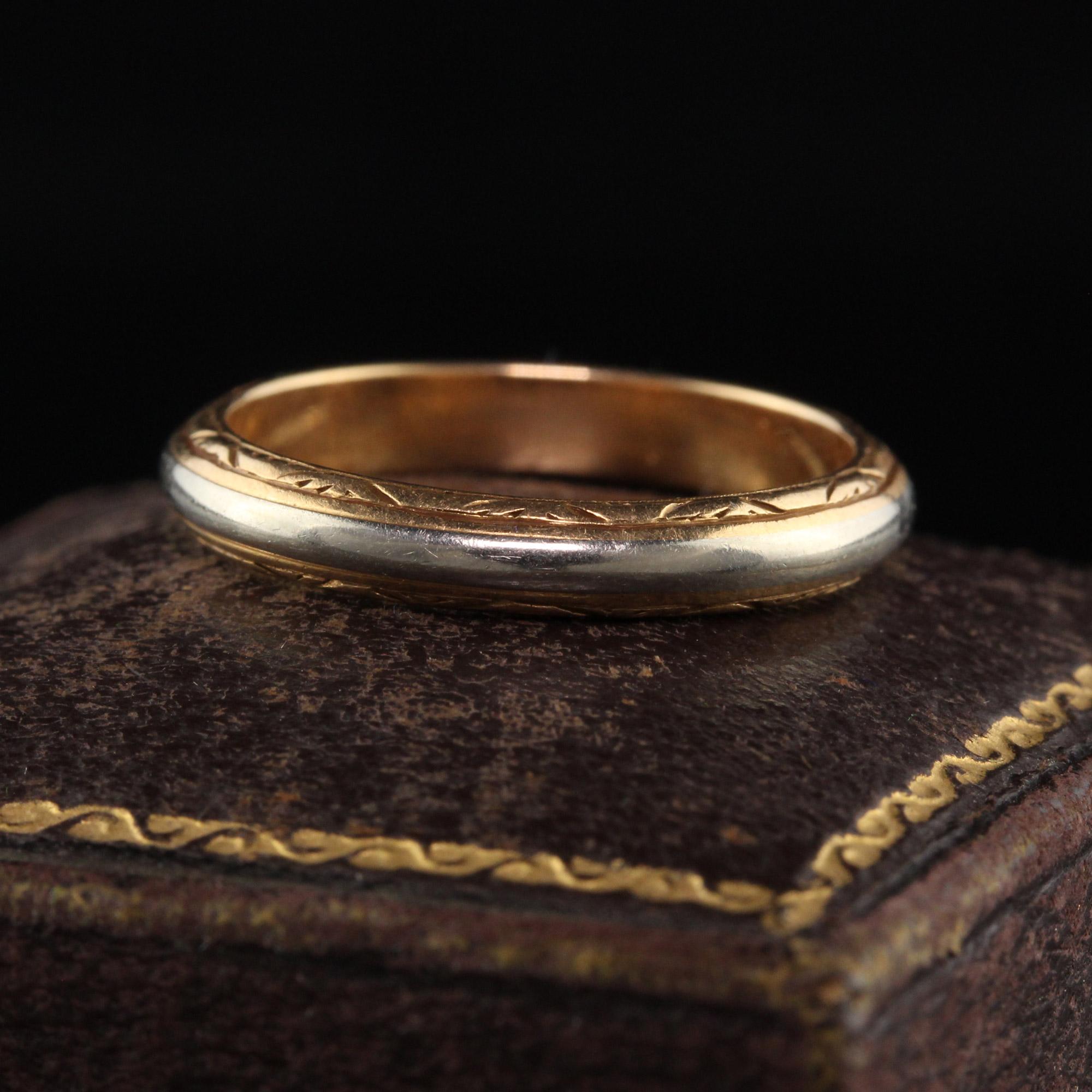Beautiful Antique Art Deco 18K Yellow Gold and White Gold Engraved Wedding Band. This beautiful band is crafted in 18K yellow gold and white gold. It has a white gold band going through the middle of the ring and has gorgeous engravings on the sides