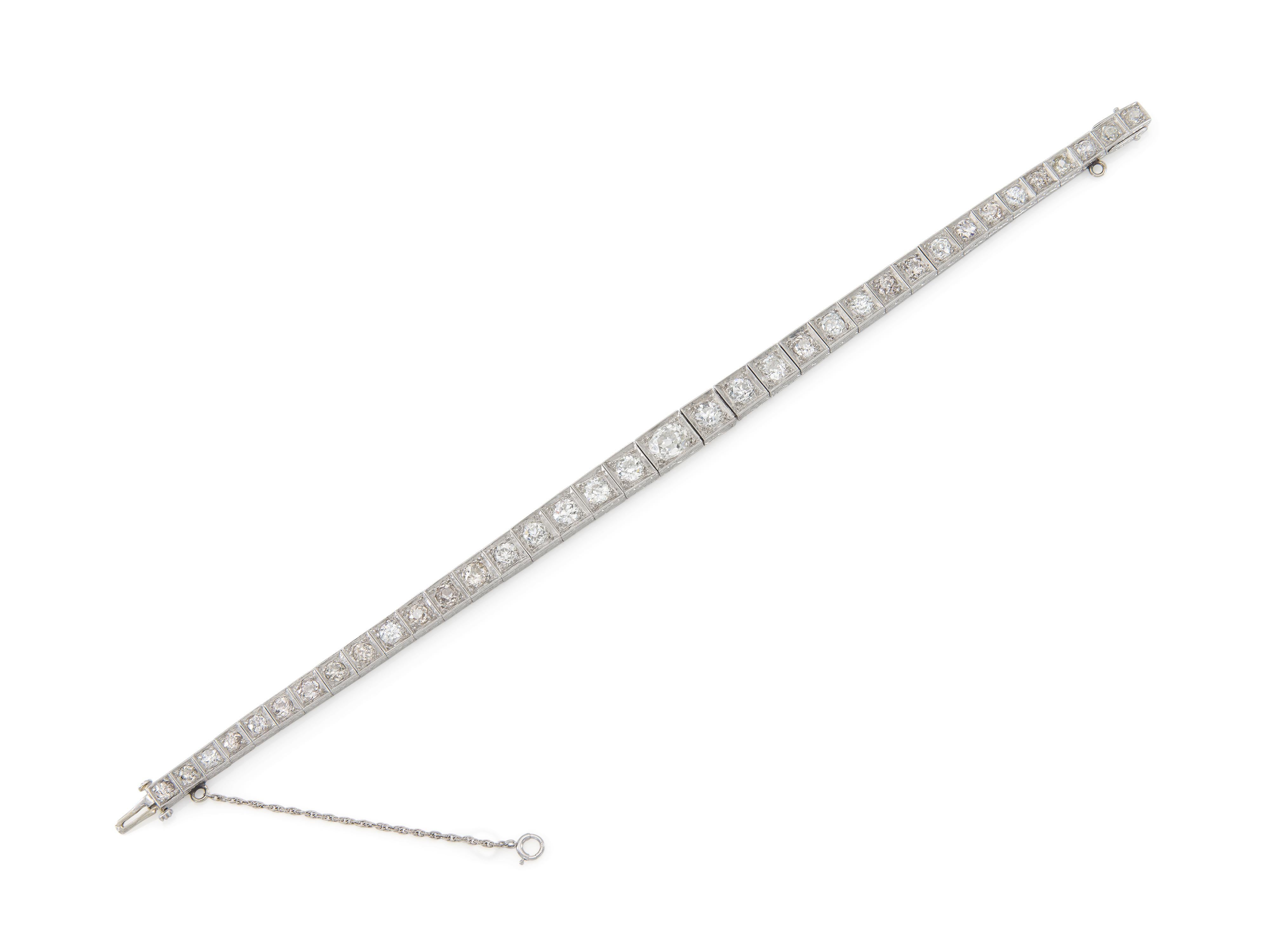 Finely crafted in platinum with canter Old Mine cut Diamond weighing approximately 2.00 carats and 35 graduating Old European cut Diamonds weighing approximately a total of 10.50 carats.
Circa 1920s
Size 7 1/2 inches