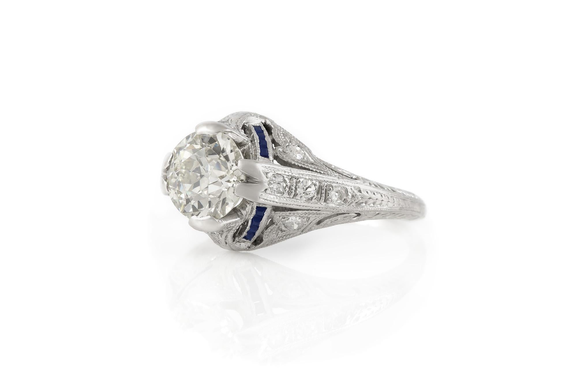 Finely crafted in platinum with an Old European cut center Diamond weighing approximately 1.30 carats, accented with blue Sapphires and 12 additional Diamonds.
Circa 1930's
Size 6, resizable