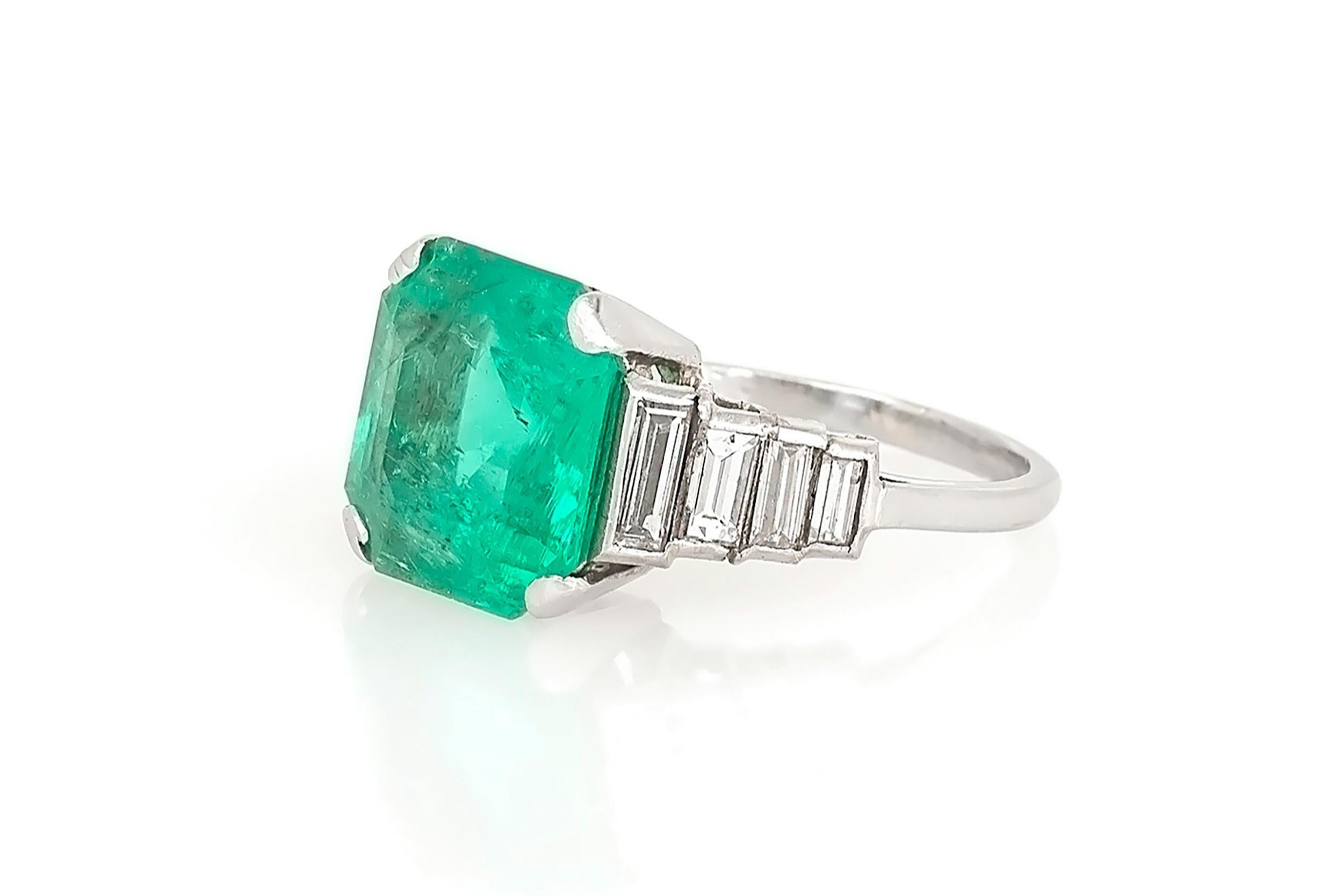 Finely crafted in platinum with a Square Emerald cut Emerald weighing approximately 5.00 carats and 8 Baguette cut Diamonds weighing a total of approximately 1.20 carats. 
Circa 1930s
Size 5 1/4, resizable
