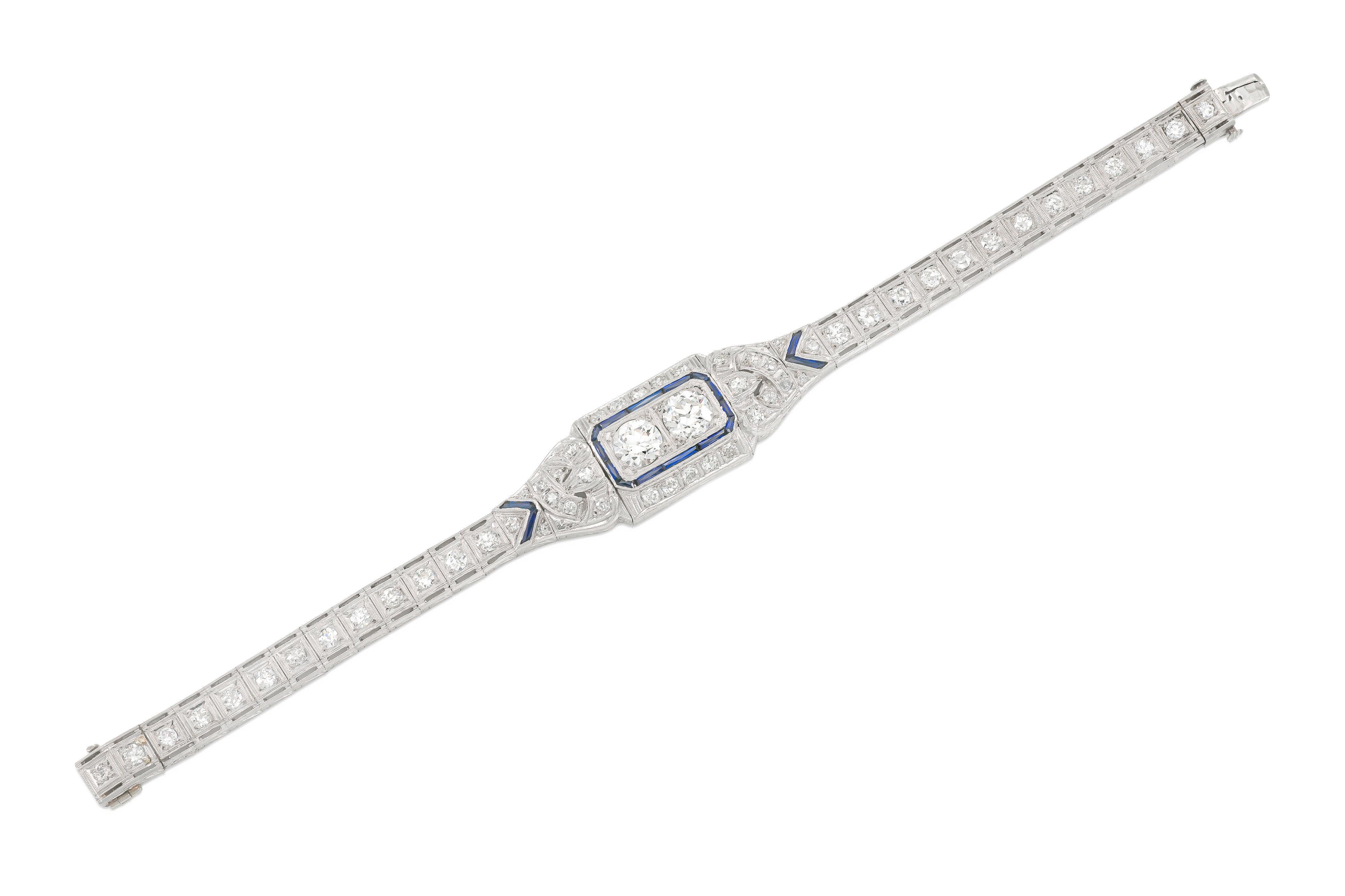 Finement réalisée en platine avec deux diamants centraux de taille européenne ancienne pesant environ 1,25 carat chacun. Le bracelet comporte des diamants plus petits de taille européenne ancienne pesant environ 3,50 carats au total et des saphirs