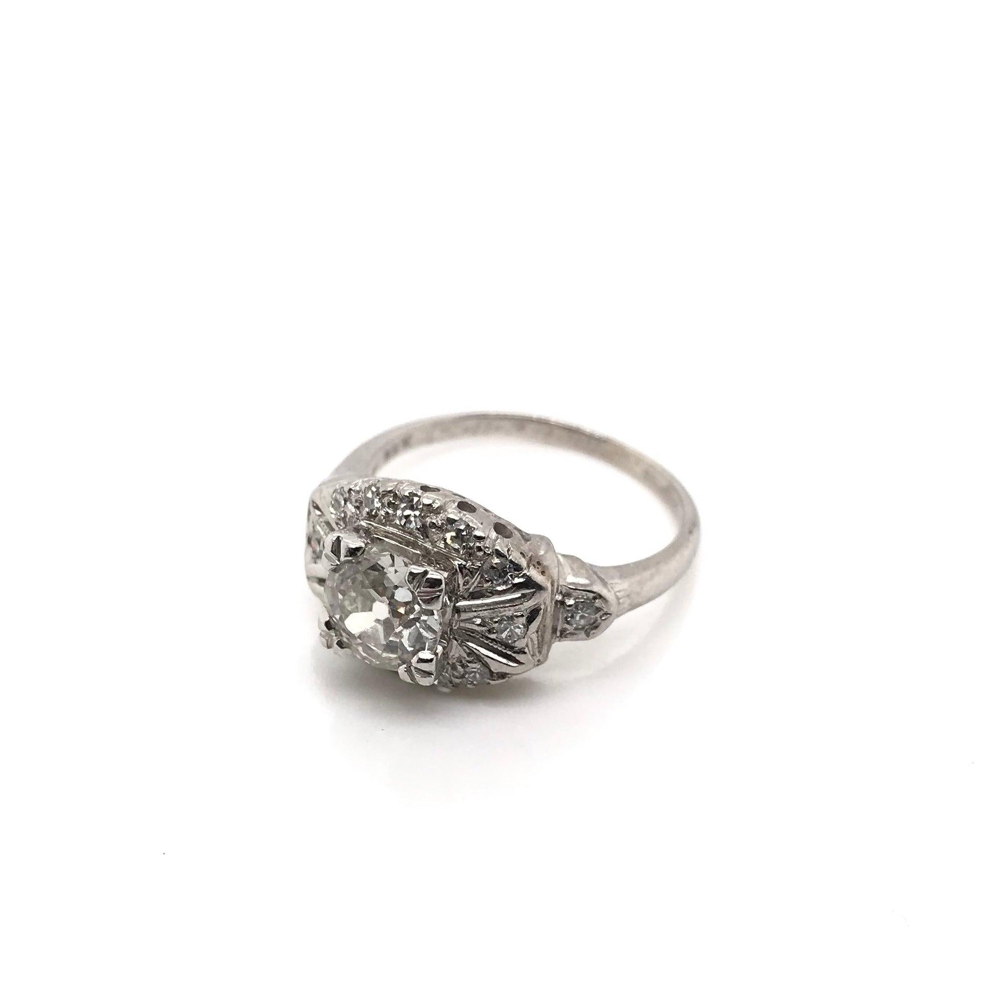 This antique piece was handcrafted sometime during the Art Deco design period (1920-1940) and was dedicated with the date 6-11-37 on the inside of the band. The setting is 14K white gold and features a center diamond measuring approximately 0.80